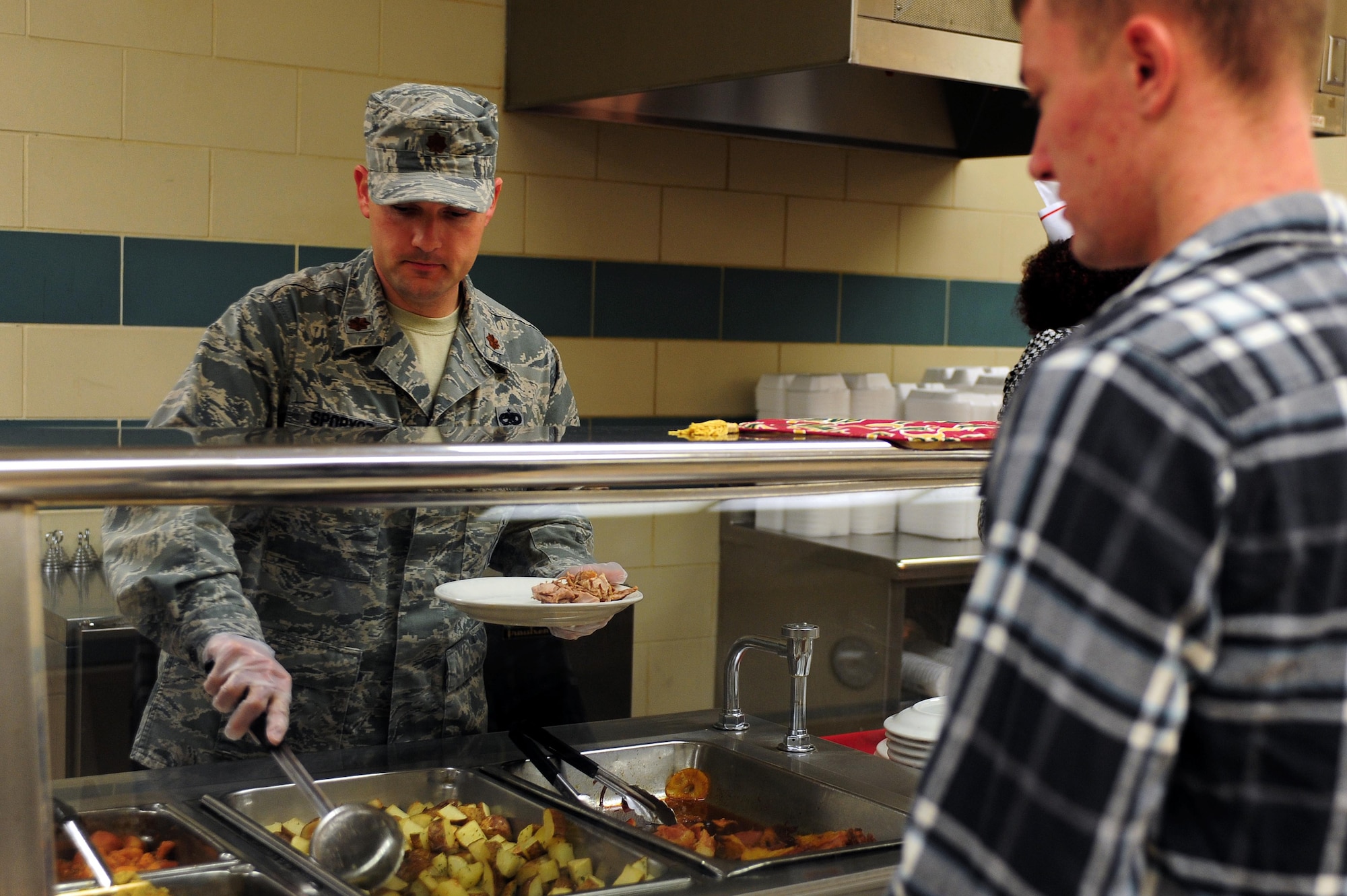 Maj. Brian Sporysz, 4th Component Maintenance Squadron commander, prepares a plate for a holiday lunch at the Southern Eagle Dining Facility on Seymour Johnson Air Force Base, N.C., Dec. 25, 2013. Individuals had a variety of delicacies to choose from, including turkey, vegetables and bread. (U.S. Air Force photo by Senior Airman John Nieves Camacho)