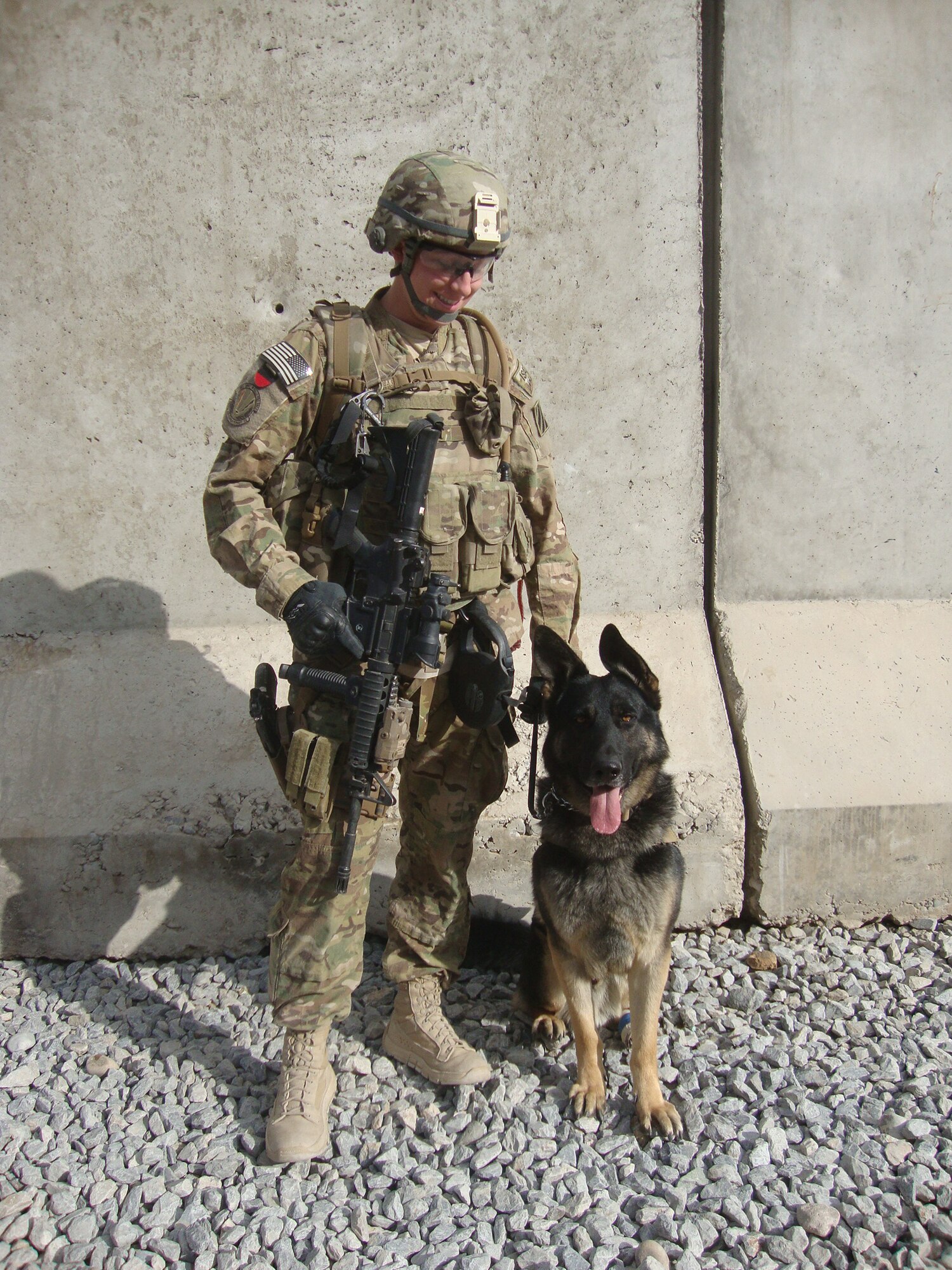 CAMP NATHAN SMITH, Afghanistan -- Jork, 17th Security Forces Squadron military working dog, and his handler Staff Sgt. Amanda Goetz pose during a deployment to Afghanistan. A memorial was held Dec. 18 for Jork who passed away in November. (Courtesy photo)