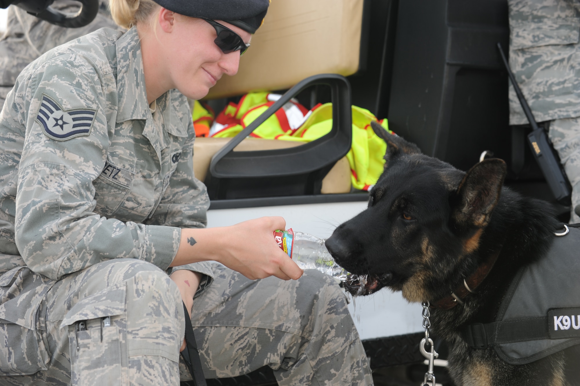 GOODFELLOW AIR FORCE BASE, TEXAS -- Jork, 17th Security Forces Squadron military working dog, helps himself to his handler’s, Staff Sgt. Amanda Goetz, water during Community Appreciation Day Nov. 19, 2011. A memorial was held Dec. 18 for Jork who passed away in November. (U.S. Air Force photo/ Staff Sgt. Laura R. McFarlane)