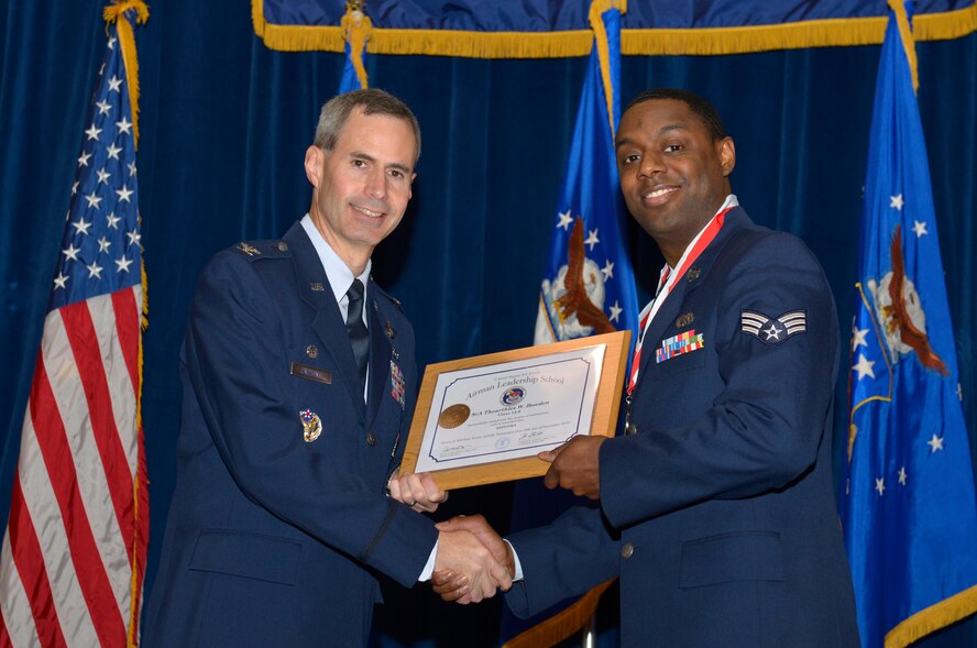 McGHEE TYSON AIR NATIONAL GUARD BASE, Tenn. - Senior Airman Thearthles W. Bowden, right, receives the Distinguished Graduate Award for Airman Leadership School Class 14-8 from Col. Timothy J. Cathcart, commander, I.G. Brown Training and Education Center, here, Dec. 19, 2013. The award is presented to students in the top 10 percent of their class and is based on objective and performance evaluations, demonstrated leadership and participation as a team player. (U.S. Air National Guard photo by Master Sgt. Kurt Skoglund/Released)