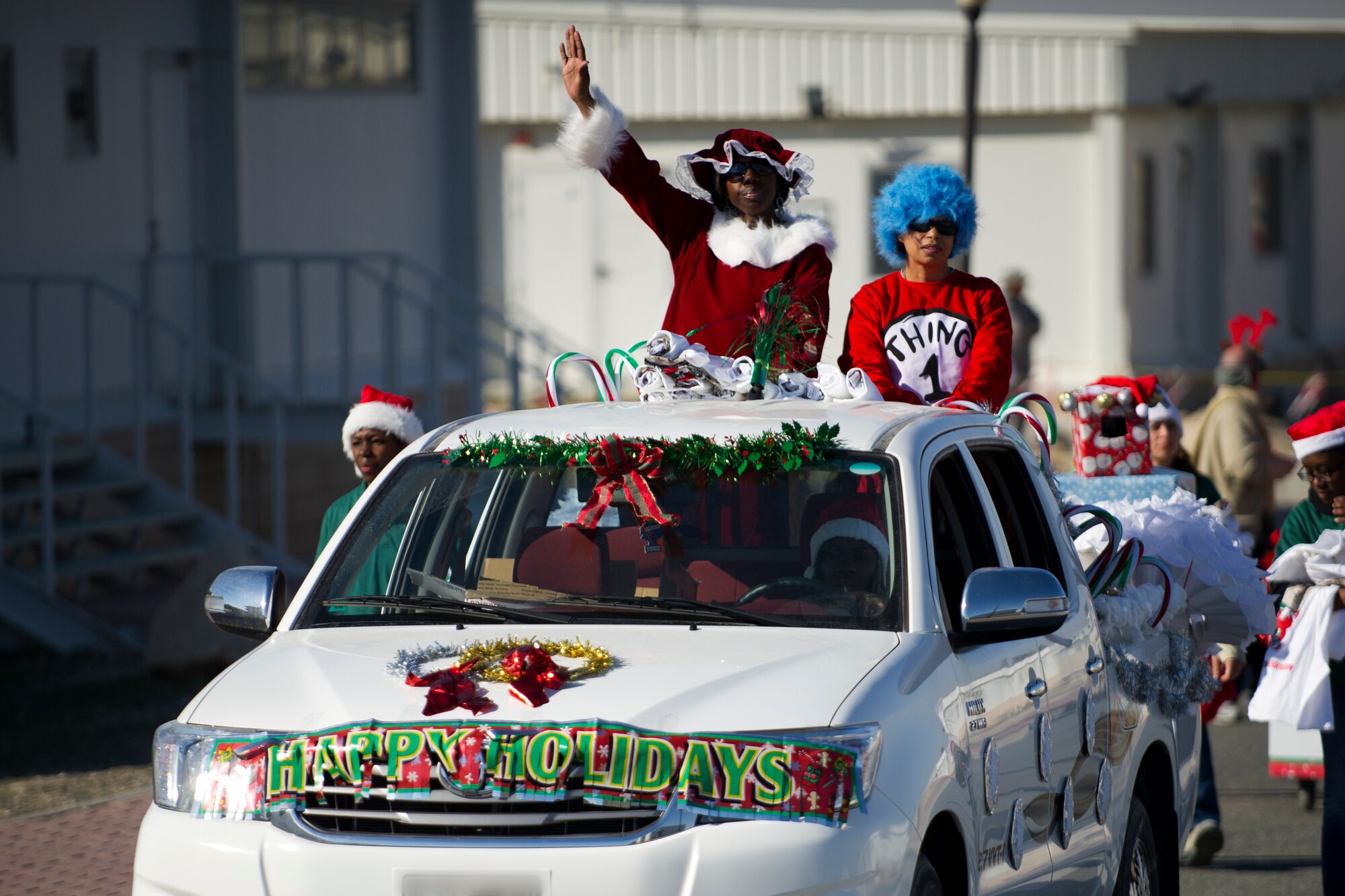 Lt. Col. Cotina Jenkins-Sellers (left), 386th Expeditionary Force Support Squadron commander, and Chief Master Sgt. Debra Mosley, 386th EFSS Chief Enlisted Manager,ride atop the float entry from the EFSS during a holiday parade held on The Rock on Dec. 25.  The parade was one of several holiday events that were orchestrated by the EFSS and other base entities to promote holiday spirit and boost morale.  (U.S. Air Force photo by Senior Master Sgt. Burke Baker)