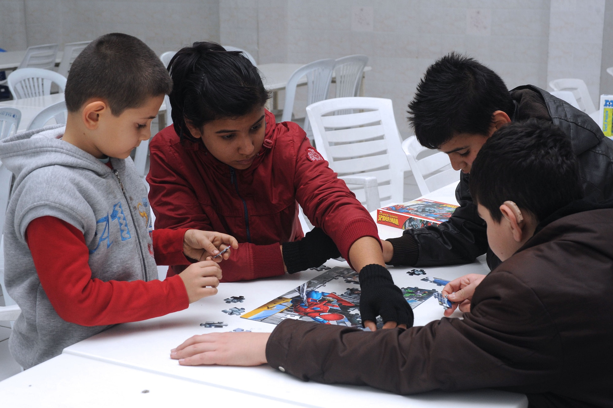 Students at Seyhan Isitme elementary school for the hearing impaired piece together a puzzle during a New Year’s celebration Dec. 26, 2013, in Adana, Turkey. Seven Team Incirlik members spent the afternoon and evening playing games, dancing and eating with the children before the night culminated with cake and the opening of presents. (U.S. Air Force photo by 1st Lt. David Liapis/Released)