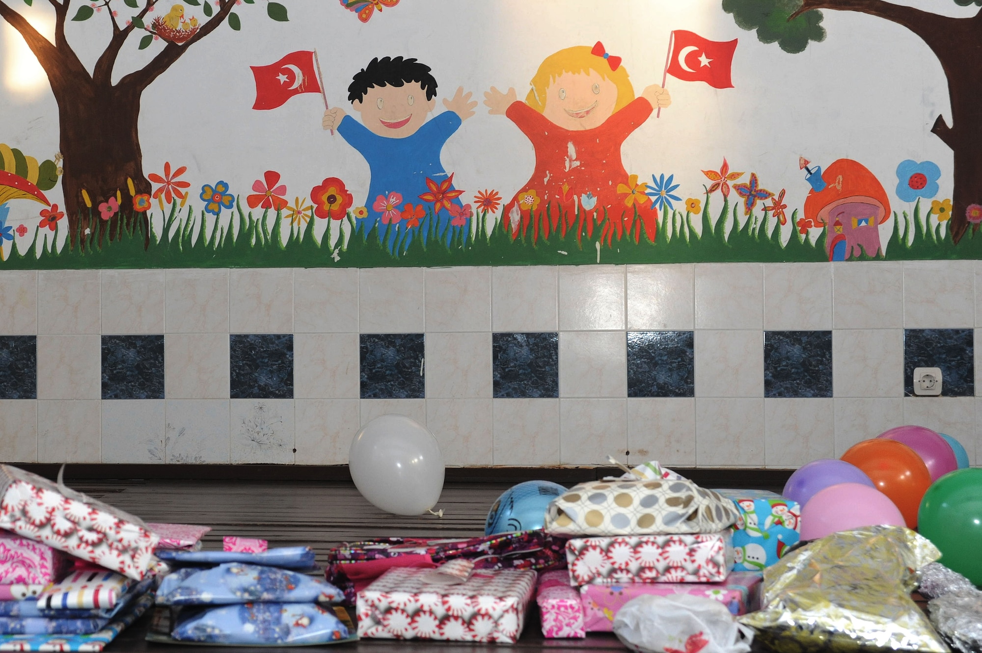 Wrapped gifts line the stage at the Seyhan Isitme elementary school for the hearing impaired Dec. 26, 2013 in Adana, Turkey. Members of Team Incirlik donated 78 gifts and a variety of decorations for a holiday party at the school that was hosted by the Incirlik chapel community. (U.S. Air Force photo by 1st Lt. David Liapis/Released)