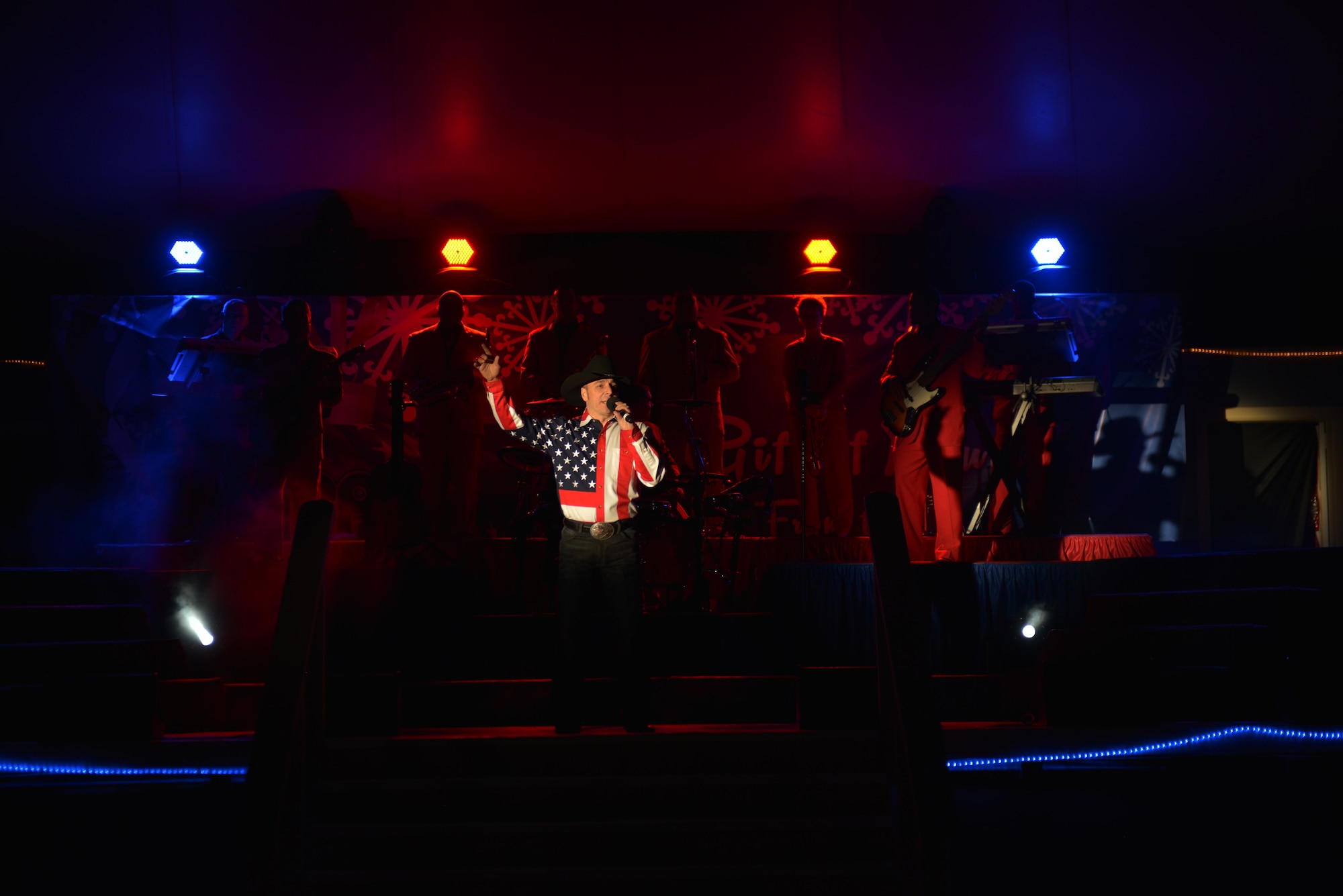 Ryan Daniel, Air Force Entertainment Group vocalist, sings to deployed service members at the 379th Air Expeditionary Wing, Southwest Asia, Dec. 26, 2013. The AFEG is comprised of 29 former Tops in Blue members who are prior service, active duty, guard and reserve Airmen who volunteered their time during the holidays to boost morale to deployed personnel. The tour concluded here after 15 performances in 10 locations worldwide. (U.S. Air Force photo by Master Sgt. David Miller)