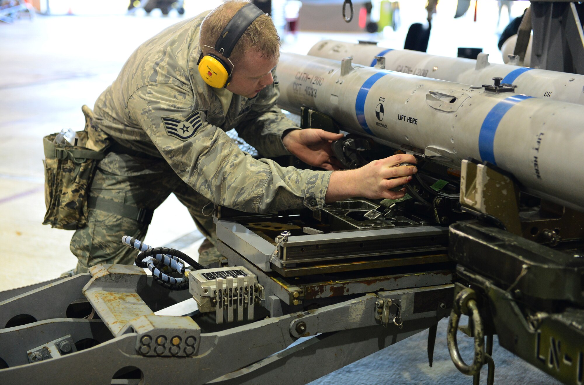 Staff Sgt. Brady Fender, 48th Munitions Squadron F-15 maintenance team chief, inspects an AIM-120 munition using an MJ-1 Lift Truck during the Royal Air Force Lakenheath, England, Load Crew of the Year competition, Dec. 19, 2013. Airmen from the 48th MUNS were competing against the clock to beat their fastest time. (Air Force photo by Airman 1st Class Dawn M. Weber/Released)
