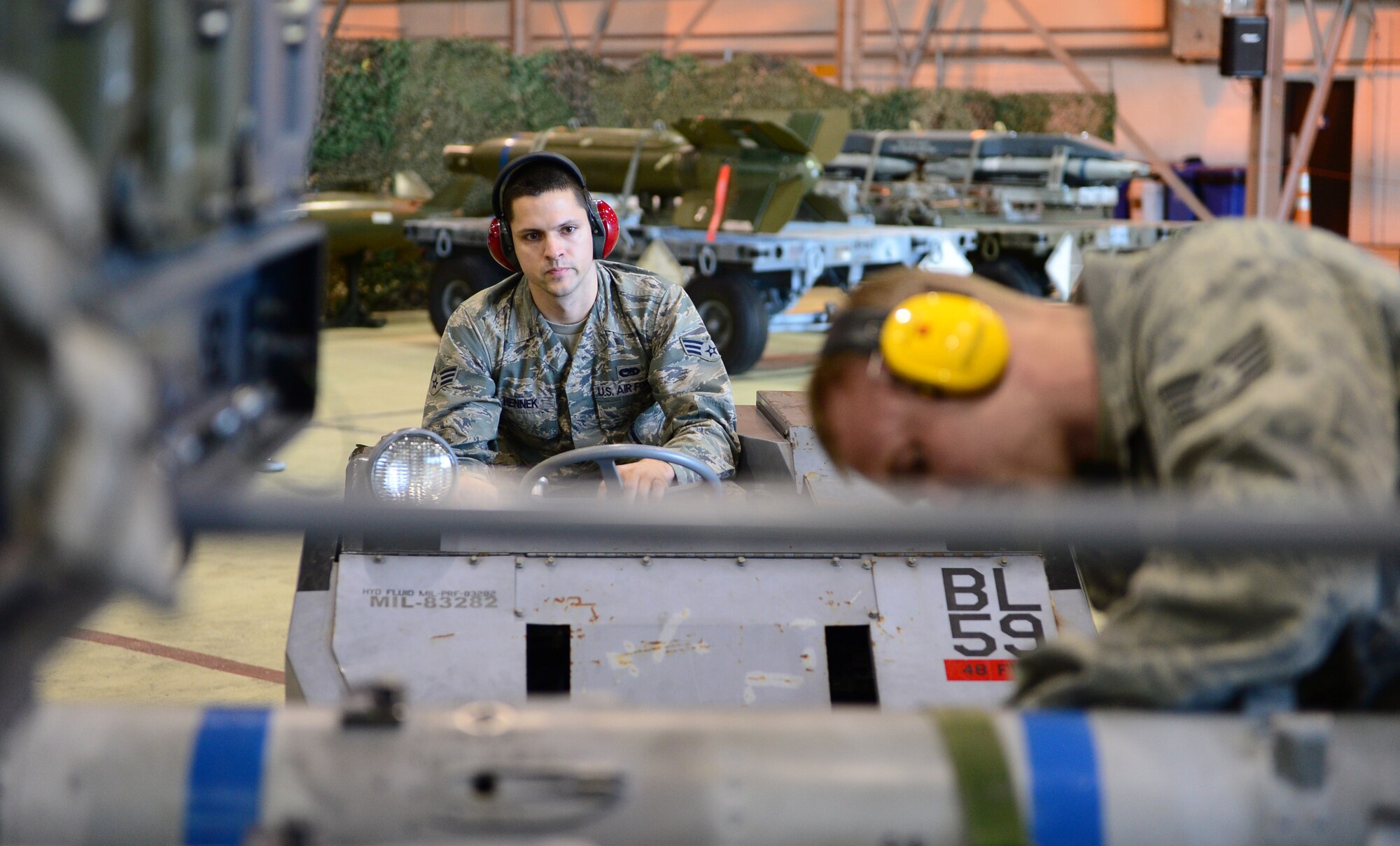 Senior Airman Adam Hennek and Staff Sgt. Brady Fender, 48th Munitions Squadron F-15 maintenance team chiefs, prepare to transport an AIM-120 munition using an MJ-1 Lift Truck during the Royal Air Force Lakenheath, England, Load Crew of the Year competition, Dec. 19, 2013. Airmen from the 48th MUNS were competing against the clock to beat their fastest time. (Air Force photo by Airman 1st Class Dawn M. Weber/Released)