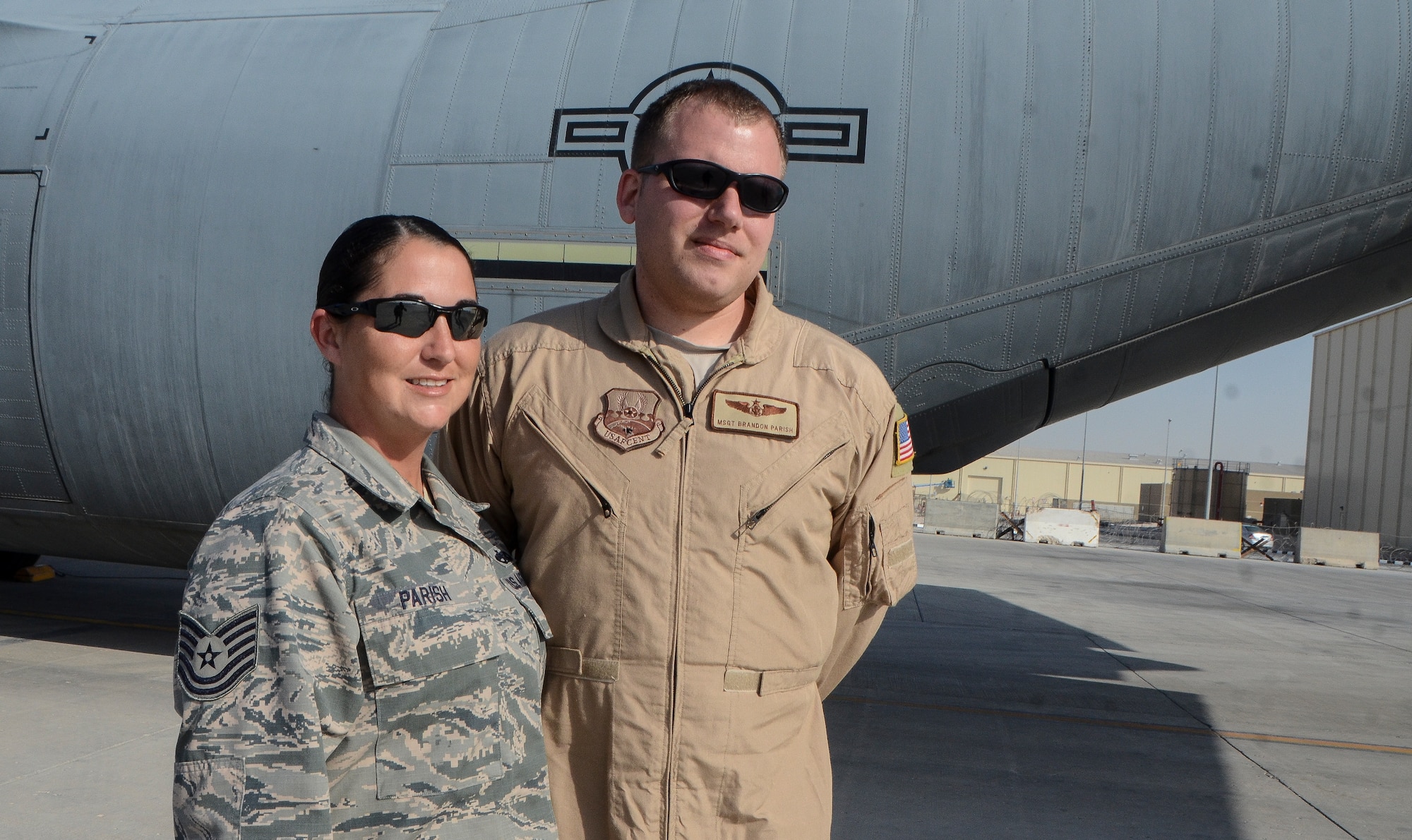 Tech. Sgt. Rachel Parish and her husband, Master Sgt. Brandon Parish, pose in front of a C-130J Super Hercules at the 379th Air Expeditionary Wing in Southwest Asia, Dec. 19, 2013. The couple, deployed from Keesler Air Force Base, Miss. and Gulfport, Miss. natives, is sharing the experience of deploying together during the holidays. Rachel is a 379th Expeditionary Aircraft Maintenance Squadron crew chief and Brandon is a 746th EAS loadmaster. (U.S. Air Force photo/Senior Airman Jared Trimarchi)