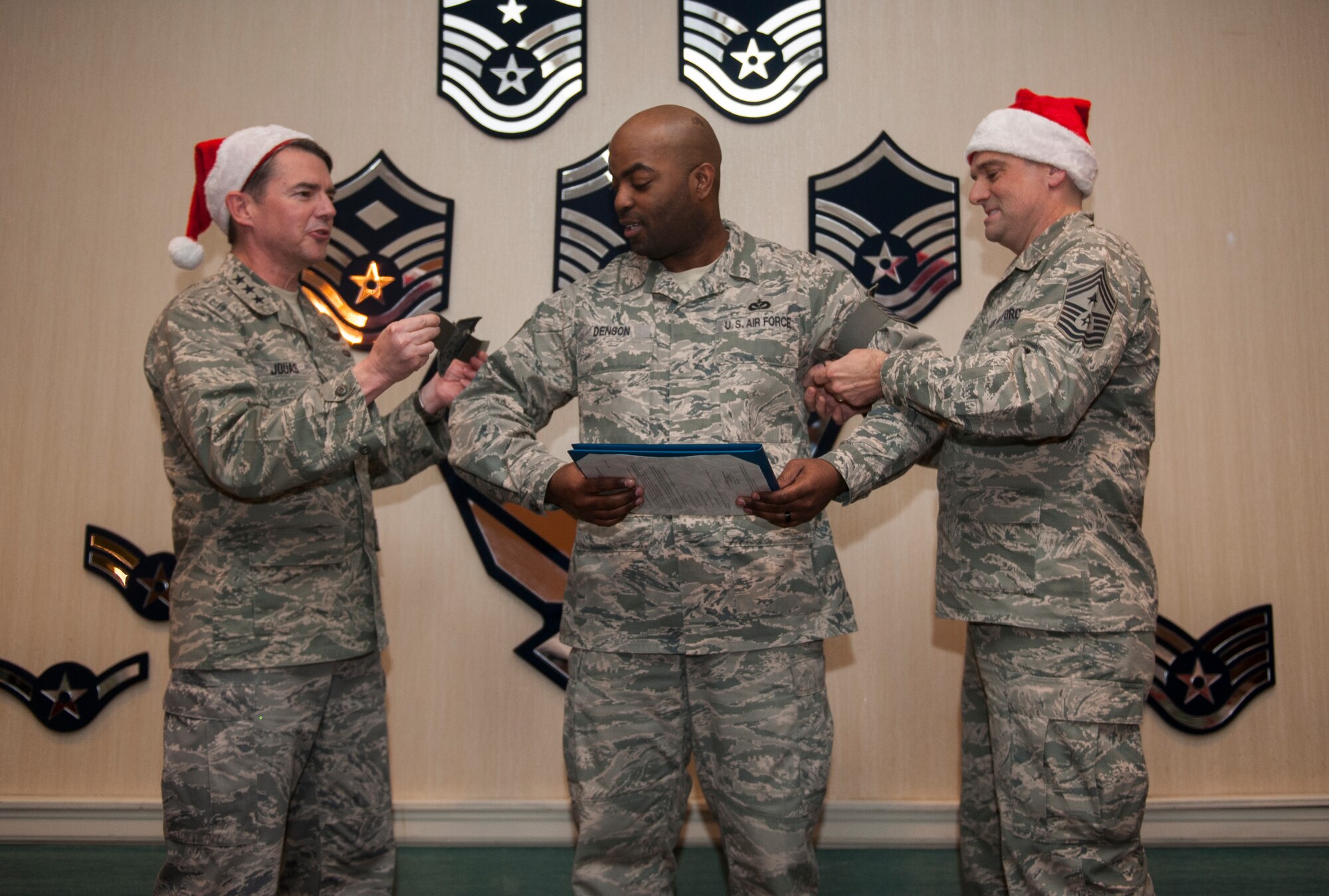 KUNSAN AIR BASE, Republic of Korea - Lt. Gen. Jan-Marc Jouas, 7th Air Force commander, left, and Command Chief Master Sgt. Scott Delveau, 7th AF Command Chief, right, attach Master Sgt. James Denson’s, 8th Communications Squadron, newest stripes at Kunsan Air Base, Republic of Korea, Dec. 20, 2013. Denson was one of three Airmen at Kunsan who was promoted through the StripesThrough Exceptional Performers program. (U.S. Air Force photo by Senior Airman Clayton Lenhardt/ Released)