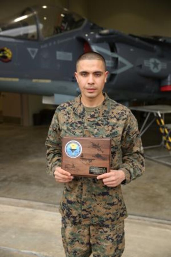 Sgt. Martin Sanchez, Jr. presents his plaque for the Naval Education and Training Command’s 2013 Junior Instructor of the Year for his work at Cherry Point’s Center for Naval Aviation Technical Training Marine Detachment Dec. 20.