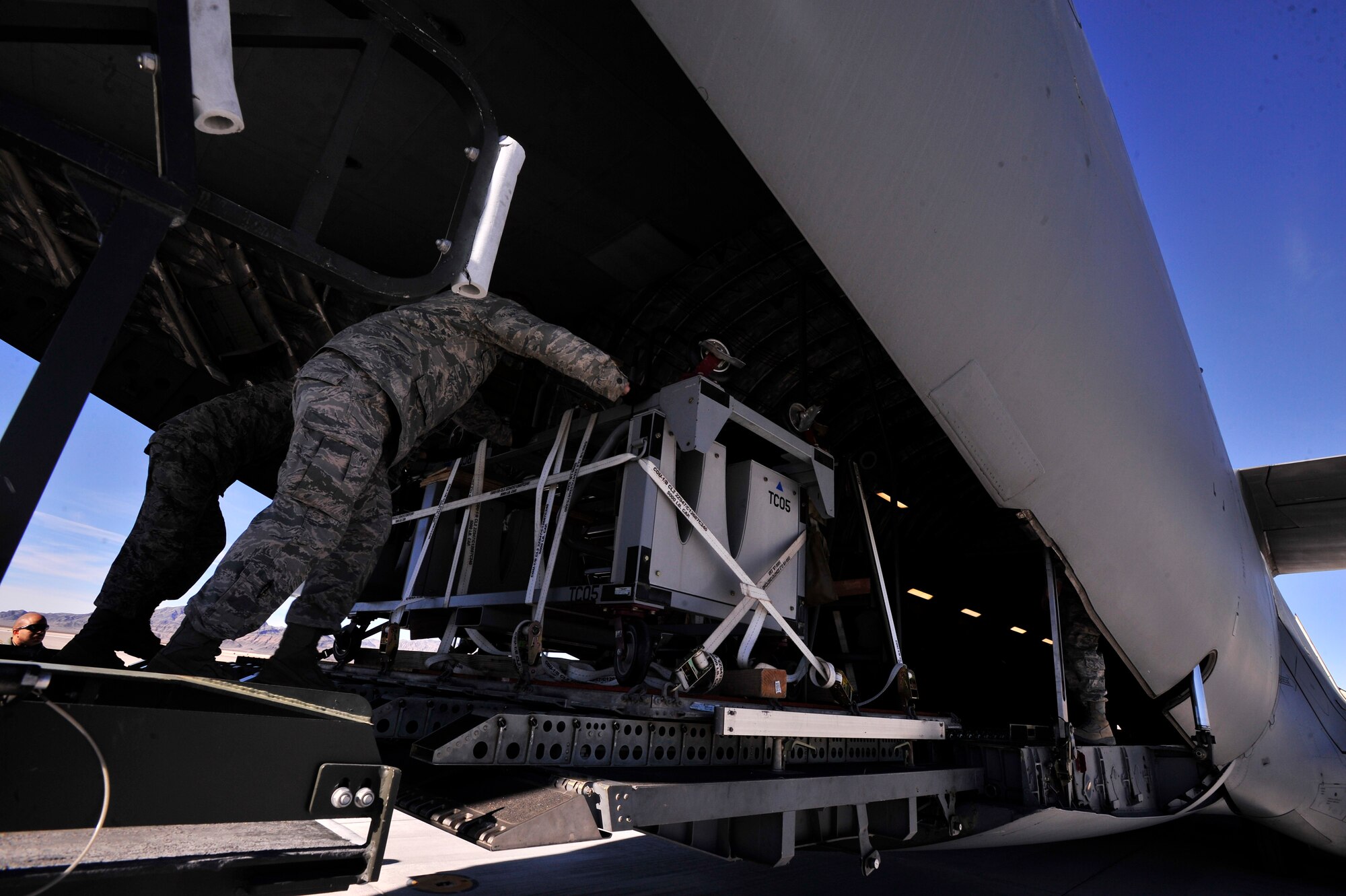 A pallet containing wing support equipment for MQ-9 Reaper remotely piloted aircraft maintenance is pushed off a loader into the cargo hold of a C-17 Globemaster Dec. 30, 2013. The pallet is one of 46 pallets of RPA equipment that were loaded onto three separate C-17s bound for overseas. (U.S. Air Force photo/Staff Sgt. A.D.)