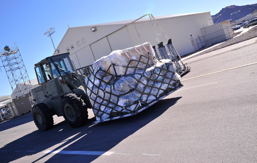 A forklift positions an aerospace ground equipment support pallet in preparation for loading onto one of three C-17 Globemaster aircraft heading to the area of responsibility Dec. 30, 2013. Forty-six cargo increments of equipment weighing approximately 64.2 short tons, or more than 128,000 pounds, were loaded onto the C-17s during the transfer. (U.S. Air Force photo/Staff Sgt. A.D.)