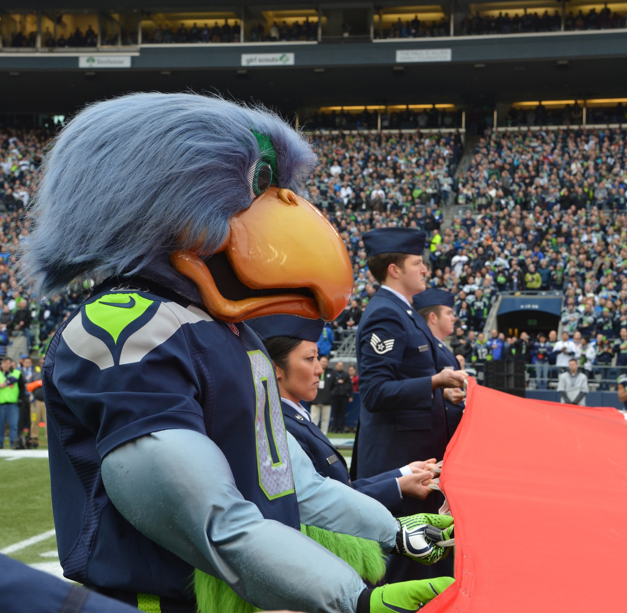 Team McChord Airmen, along with Blitz, the Seattle Seahawks mascot, hold the U.S. field flag as part of the pregame ceremony, Dec. 29, 2013 at CenturyLink Field in Seattle. The field flag is so big that it requires a minimum of 35 people to hold it and extends from the touchdown line out to the 15-yard-line on the field. (U.S. Air Force photo/Master Sgt. Todd Wivell)