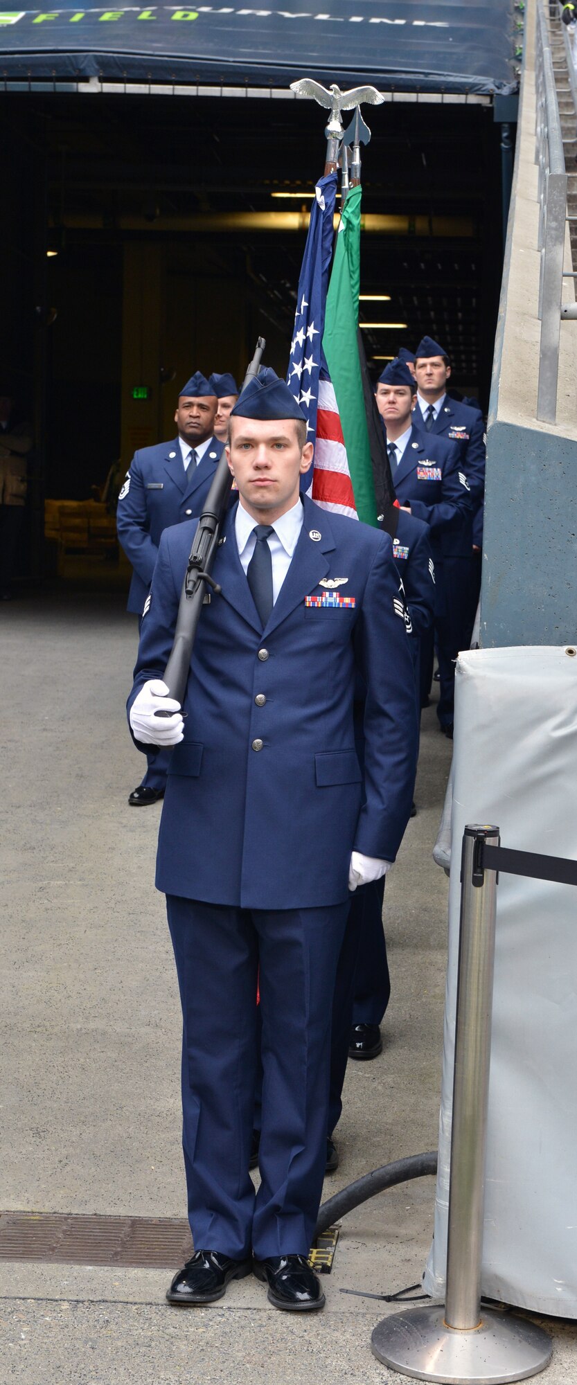 Senior Airman Matt Vanourek, 728th Airlift Squadron, leads the flag detail out on to the Seattle Seahawks field as part of the pregame ceremony, Dec. 29, 2013 at CenturyLink Field in Seattle. More than 40 Team McChord Airmen participated in the pregame ceremony for the Seahawks final home game of 2013. (U.S. Air Force photo/Master Sgt. Todd Wivell)