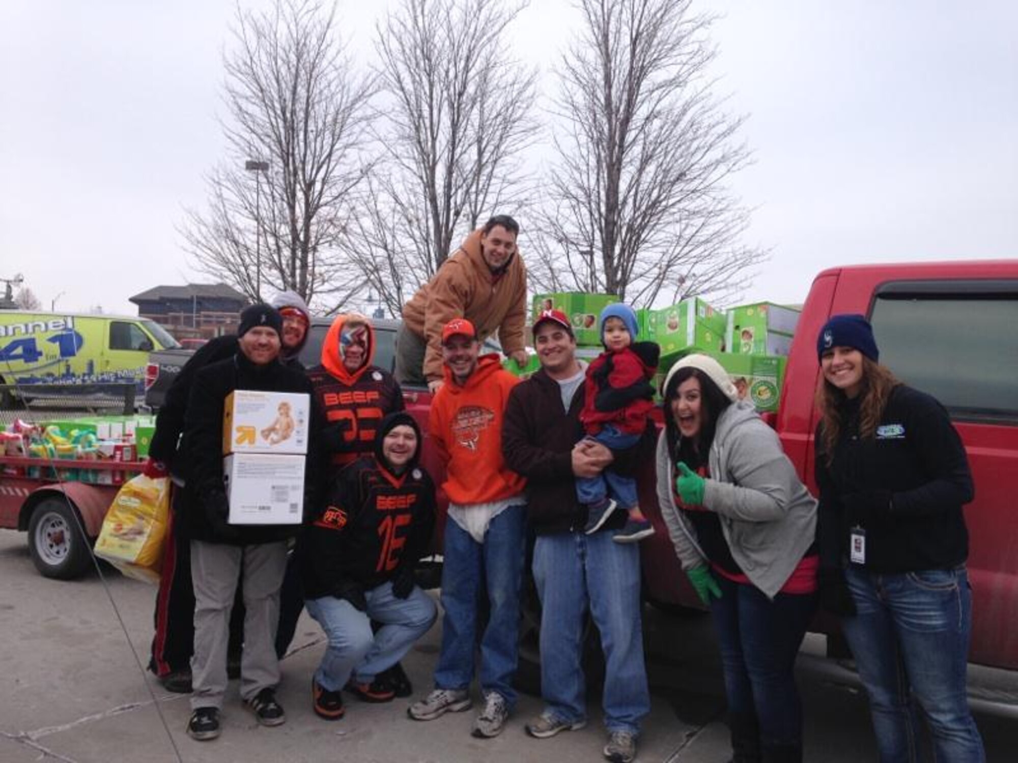 Steve Morris, 55th Security Forces Squadron, who is in the center of the photo holding his son, and U.S. Air Force Airman 1st Class Jeff Krambeer, 55th Force Support Squadron, in the back of truck, unload donated diapers to the Lydia House in Omaha as part of Operation No Butts Left Behind along with members of the Omaha Beef football team and the Big Party Morning show.  In just one week a group of Team Offutt volunteers collected a combined diaper and cash donation of 17,889 diapers for this program. (Courtesy photo)