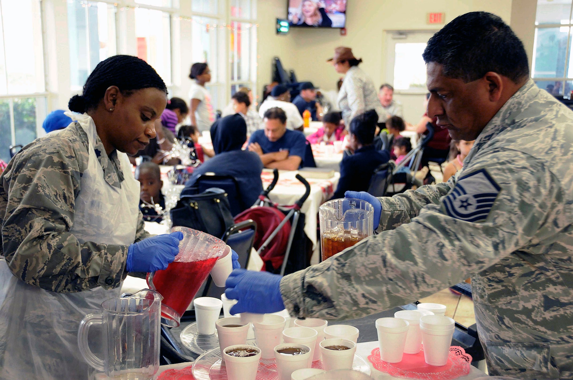 Air Force Reserve members Lt. Col. Ethel Watson and Master Sgt. Robert Oyarvide from Homestead Air Reserve Base, Fla., help serve food and drinks at the Chapman Partnership Homeless Assistance Center in Homestead, Fla., Dec. 25. For the third year in a row, volunteers from the base helped serve over 300 meals at the shelter. (U.S. Air Force photo/Senior Airman Nicholas Caceres)