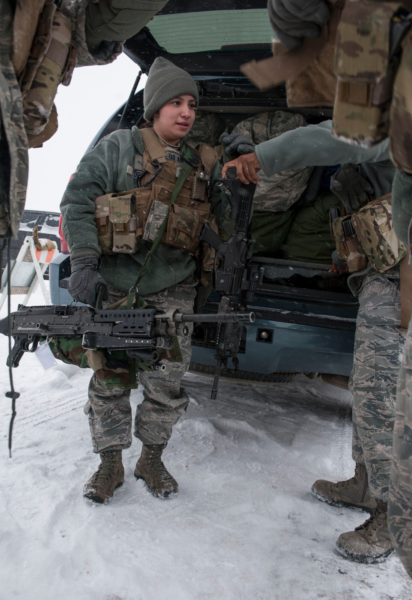 Airman 1st Class Jesmeralda Torres, 91st Missile Security Forces Squadron response force leader, unloads weaponry with her flight-mates after returning from the missile field to Minot Air Force Base, N.D. Dec. 13, 2013. Members of the 91st MSFS operate on 12-hour shifts, and are on alert 24/7, 365 days a year, ready to deploy at a moment's notice to launch and missile alert facilities. (U.S. Air Force photo/Senior Airman Stephanie Sauberan)