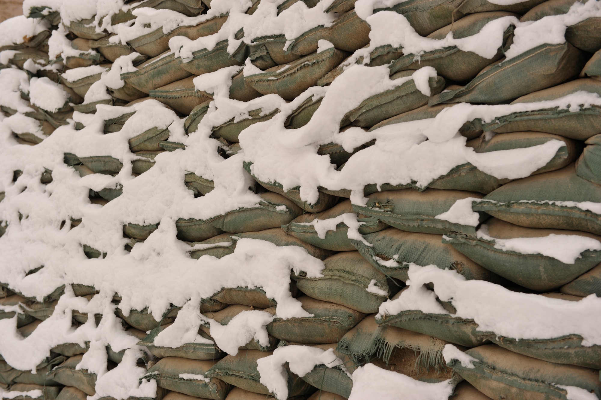 A wall of sandbags sits covered in snow on Bagram Airfield, Afghanistan, after the first snowfall of the year, Dec. 30, 2013.(U.S. Air Force photo by Senior Master Sgt. Gary J. Rihn/Released)