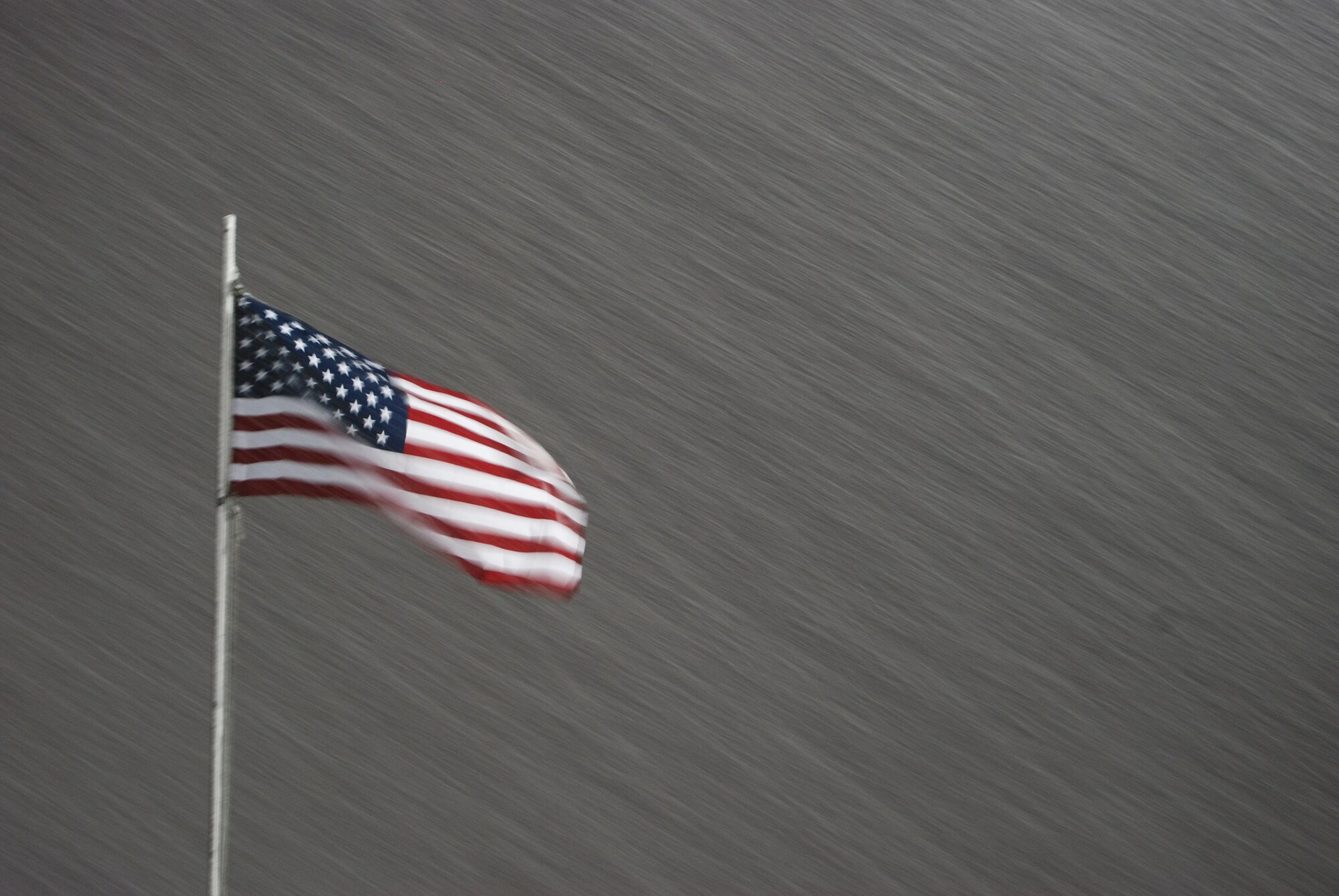 An American flag blows in the wind during a snowstorm at Bagram Airfield, Afghanistan, Dec. 29, 2013. Total snow accumulation was approximately 3 inches. (U.S. Air Force Photo by Capt. Brian Wagner/Released)