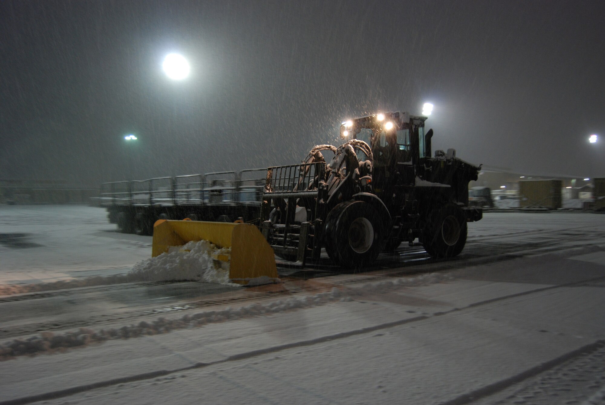 A 455th Expeditionary Aerial Port Squadron Airman plows the aerial port vehicle yard during a snowstorm, Dec. 29, 2013 at Bagram Airfield, Afghanistan. Total snow accumulation was approximately 3 inches. (U.S. Air Force photo by Capt. Brian Wagner/Released)