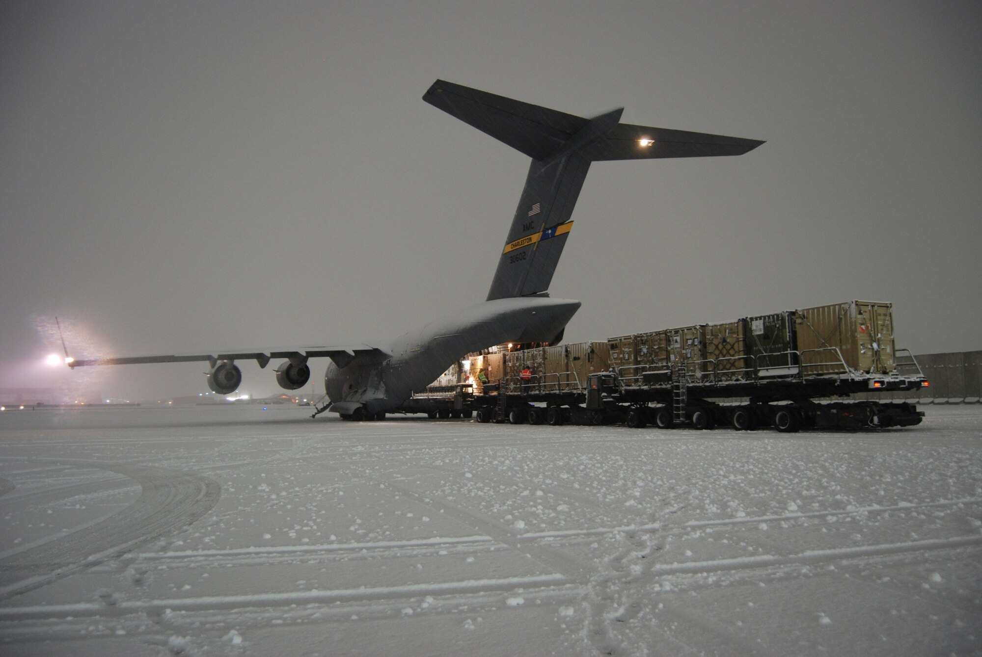 Airmen from the 455th Expeditionary Aerial Port Squadron load a C-17 Globemaster III at Bagram Airfield, Afghanistan, Dec. 29, 2013. The aircrew and aerial port Airmen downloaded and uploaded vehicles and cargo during the snowstorm. (U.S. Air Force Photo by Capt. Brian Wagner/Released)