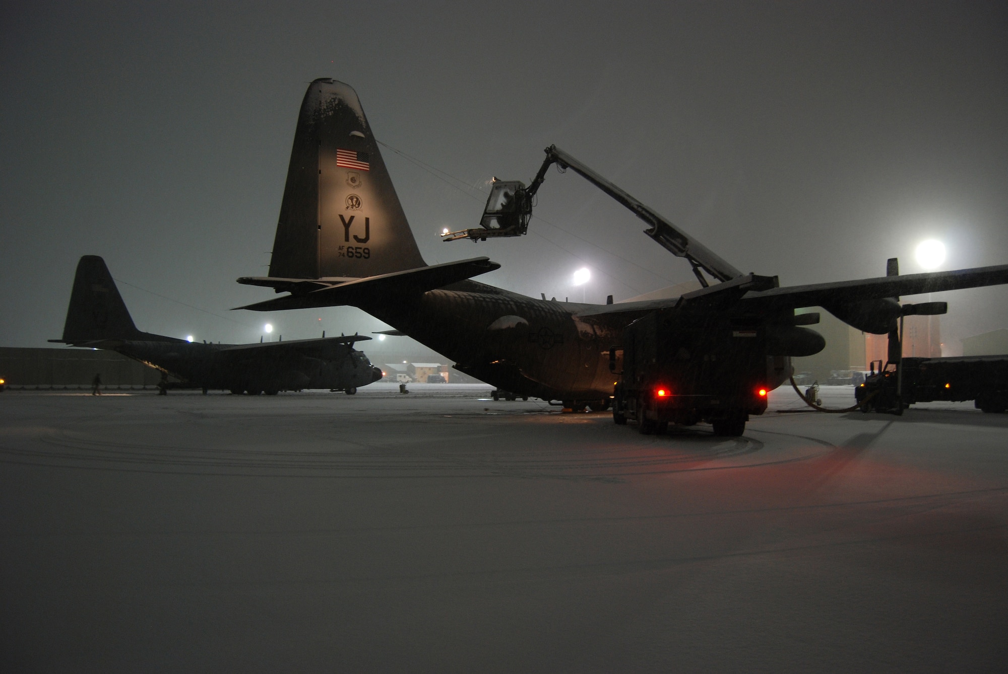 A de-icing team works to prepare a C-130 Hercules for a mission during a snowstorm Dec. 29, 2013 at Bagram Airfield, Afghanistan. Total snow accumulation was approximately 3 inches. (U.S. Air Force Photo by Capt. Brian Wagner/Released)