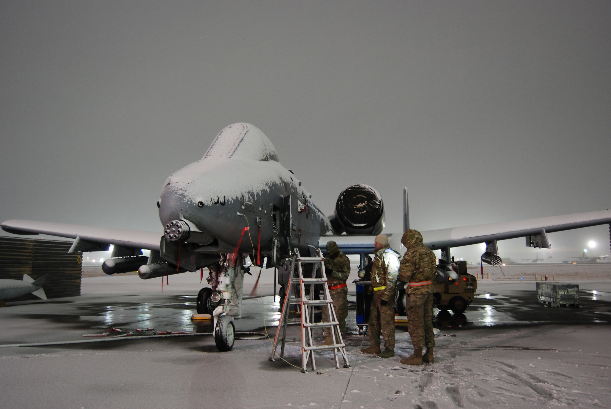 A maintenance team works on a A-10 Thunderbolt II during a snowstorm Dec. 29, 2013 at Bagram Airfield, Afghanistan.Total snow accumulation was approximately 3 inches. (U.S. Air Force Photo by Capt. Brian Wagner/Released)