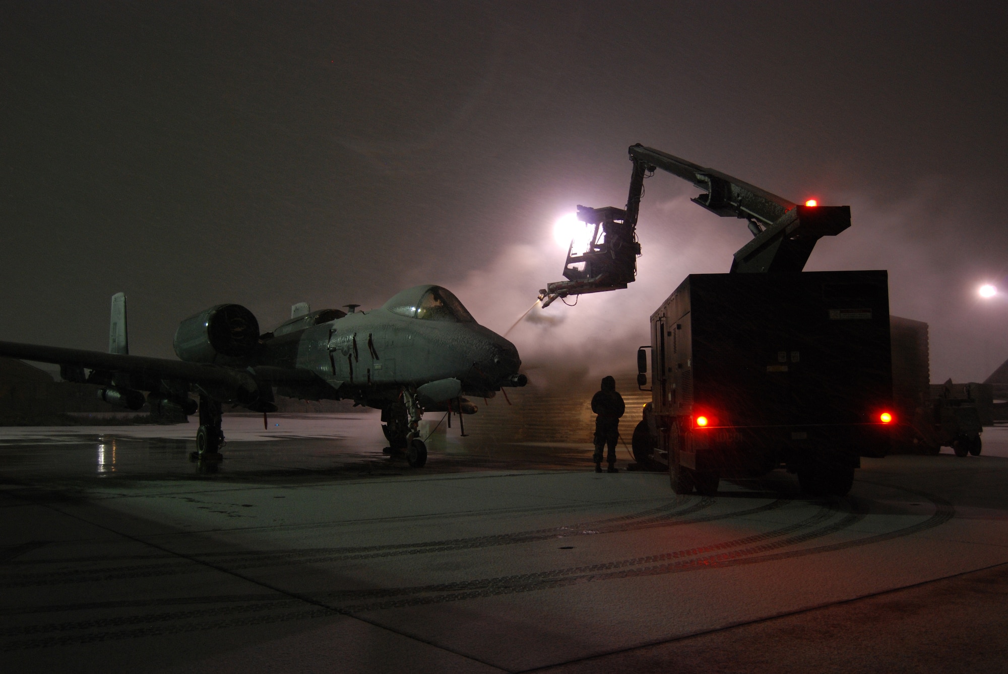 A de-icing team works to prepare an A-10 Thunderbolt II for a mission during a snowstorm Dec. 29, 2013 at Bagram Airfield, Afghanistan. Total accumulation was approximately 3 inches. (U.S. Air Force Photo by Capt. Brian Wagner/Released)