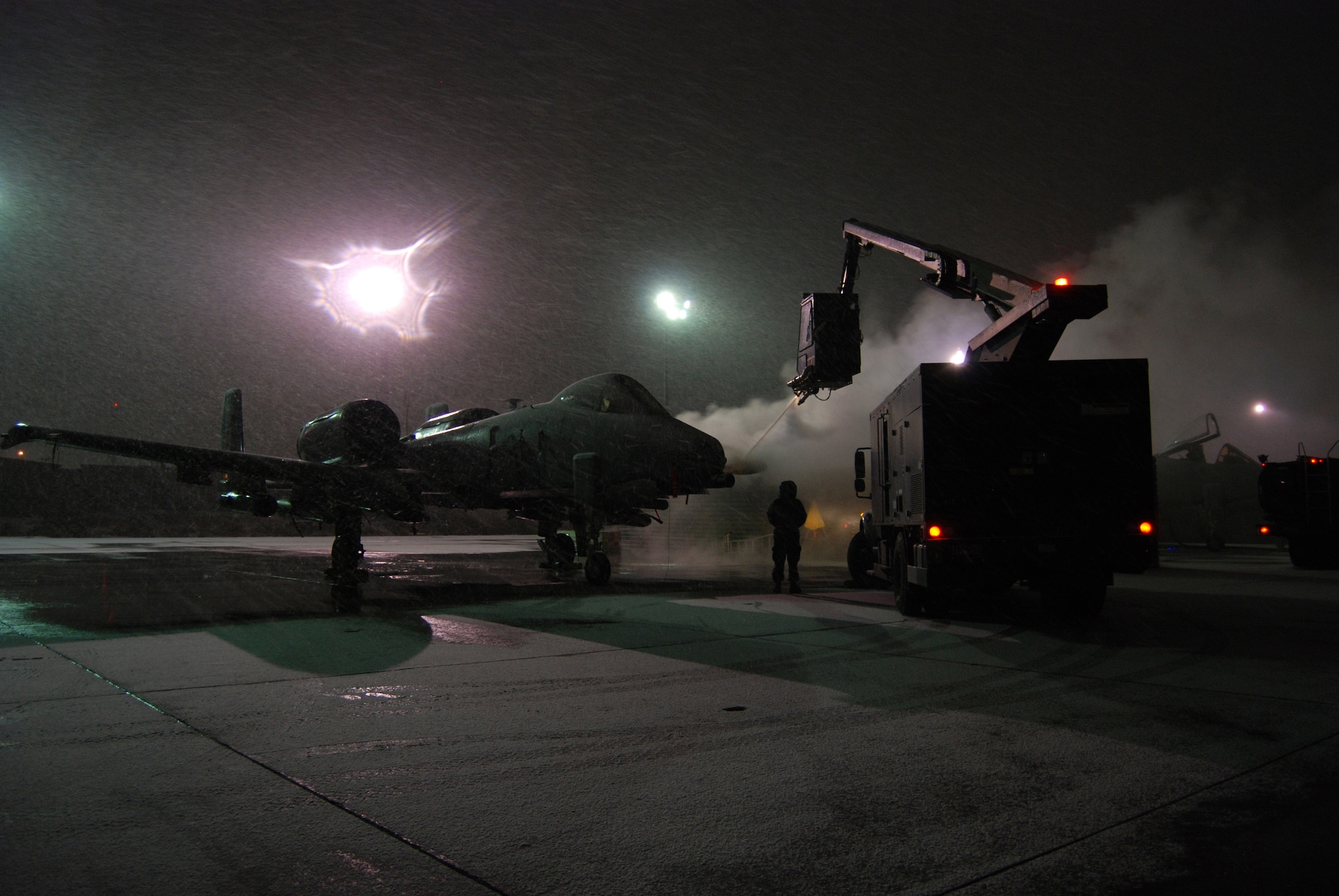 A de-icing team works to prepare an A-10 Thunderbolt II for a mission during a snowstorm Dec. 29, 2013 at Bagram Airfield, Afghanistan.Total accumulation was approximately 3 inches. (U.S. Air Force Photo by Capt. Brian Wagner/Released)