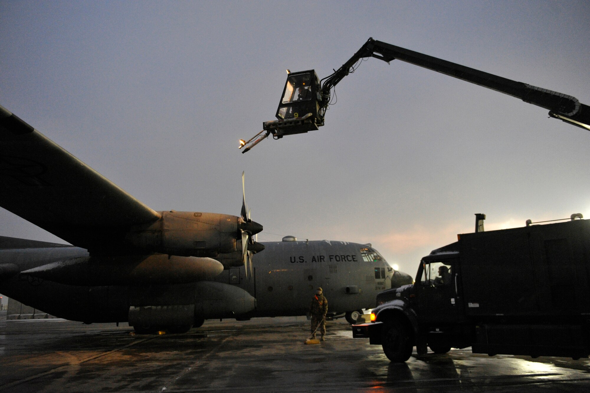 Airmen at Bagram Airfield, Afghanistan, de-ice a C-130 after the first snow of the year there, December 29, 2013.(U.S. Air Force photo by Senior Master Sgt. Gary J. Rihn/Released)
