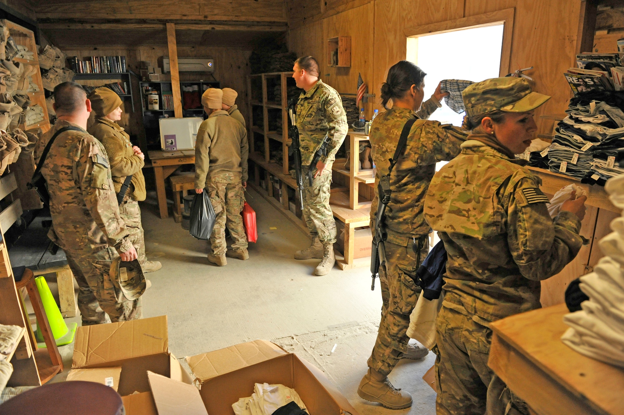 Airmen at Bagram Airfield, Afghanistan, look over the inventory at the Airman's Attic, Dec. 28, 2013. A group of Airmen recently renovated the facility, which allows Airmen to drop off excess uniform items that can then be used by other Airmen.(U.S. Air Force photo by Senior Master Sgt. Gary J. Rihn/Released)