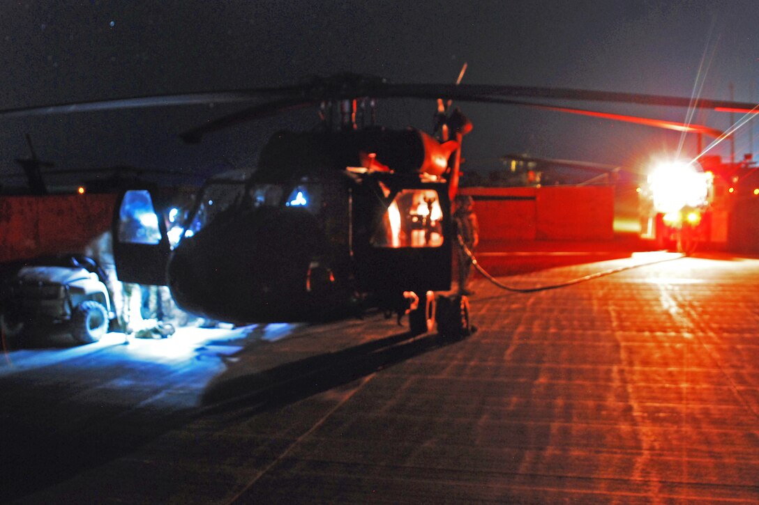 U.S. soldiers prepare their UH-60M Black Hawk helicopter for a night personnel movement mission on Forward Operating Base Shank, Afghanistan, Dec. 23, 2013. The soldiers are assigned to Company C, 2nd Battalion Assault, 10th Combat Aviation Brigade.
