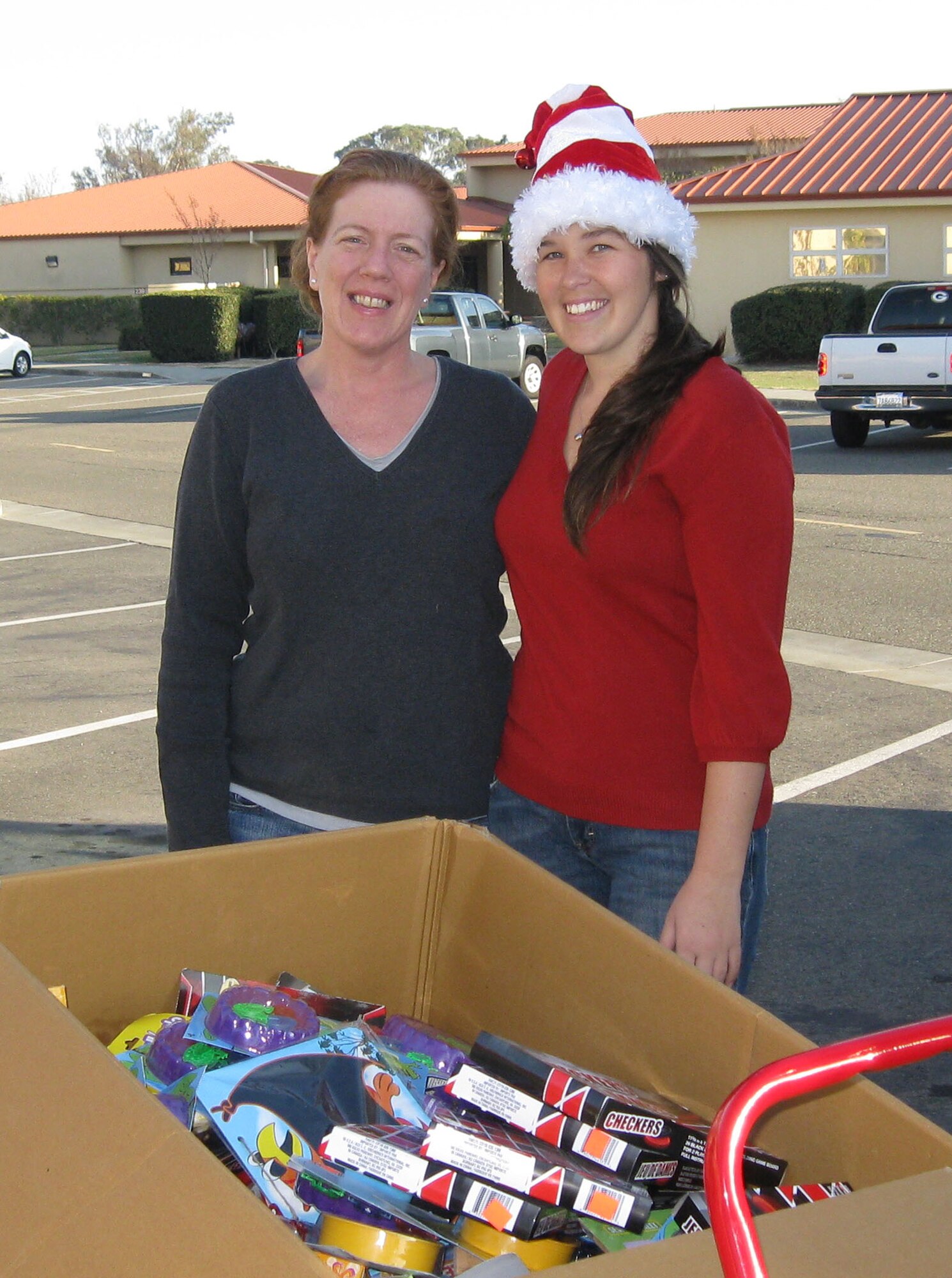 TRAVIS AIR FORCE BASE, Calif. -- Senior Master Sgt. Rita Houchin, 349th Air Mobility Wing chaplains office and Britney Cipolla, Airmen and Family Readiness Center director, help load a big box of donated toys during the 349th Air Mobility Wing Chaplain's Annual Holiday Food Drive. (U.S. Air Force photo/Patti Schwab-Holloway) 
