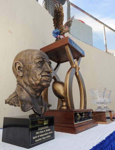 The Omar N. Bradley Spirit of Independence Award is displayed with the AdvoCare V100 Bowl Champsionship trophy and the Most Valuable Player trophies at the AdvoCare V100 Bowl in Shreveport, La., Dec. 31, 2013. This award has been given out annually at the AdvoCare V100 Bowl after the Sports Foundation directors decided to recognize outstanding American citizens with the Spirit of Independence Award. This year it was presented to the Doolittle Raiders, who were the first U.S. air retaliation attack after the attack on Pearl Harbor. (U.S. Air Force photo/ Senior Airman Kristin High)