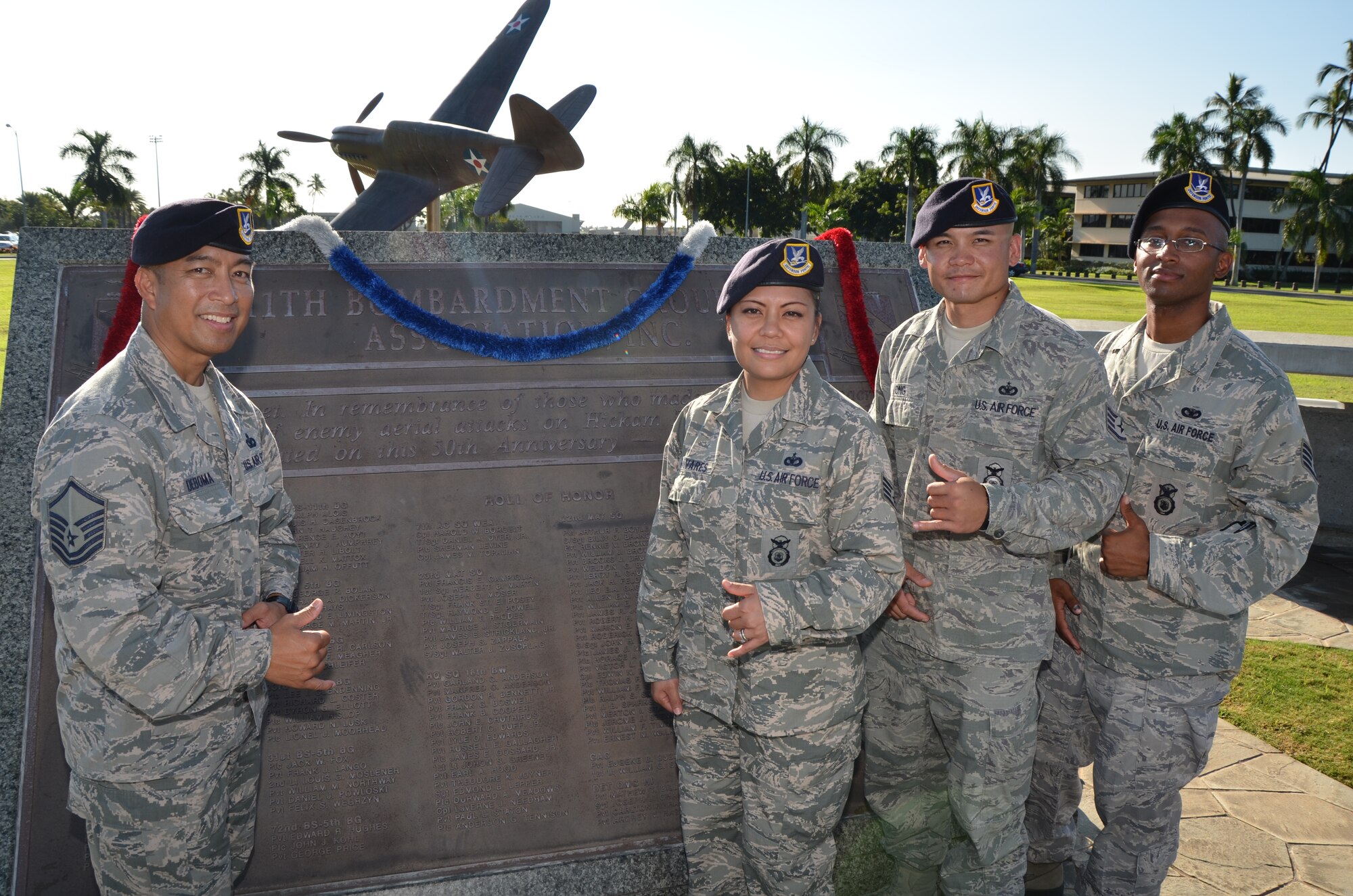 Master Sgt. Lyndon "Lenny" Deboma, left, action officer with the 624th Security Forces Squadron, 624th Regional Support Group, poses for a photo with three new members of his squadron as he gives them a tour of historical points around Hickam Field, Joint Base Pearl Harbor-Hickam, Hawaii, Dec. 7, 2013. From right are Staff Sgts. Lamarkius Cox, Kevin Ong, and Louisa Tavares of the 624th SFS. (U.S. Air Force photo by Tech. Sgt. Phyllis Keith)