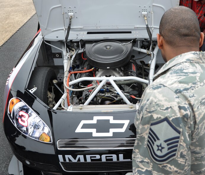 Master Sgt. Moises Martinez, 2nd Maintenance Squadron aerospace ground equipment NCO in-charge, looks at an engine inside of a Chevrolet Impala on Barksdale Air Force Base, La., Dec. 28, 2013. Richard Childress Racing brought the impala to Barksdale as part of the promotion for the Advocare V100 Bowl. (U.S. Air Force photo/Senior Airman Joseph A. Pagán Jr.)