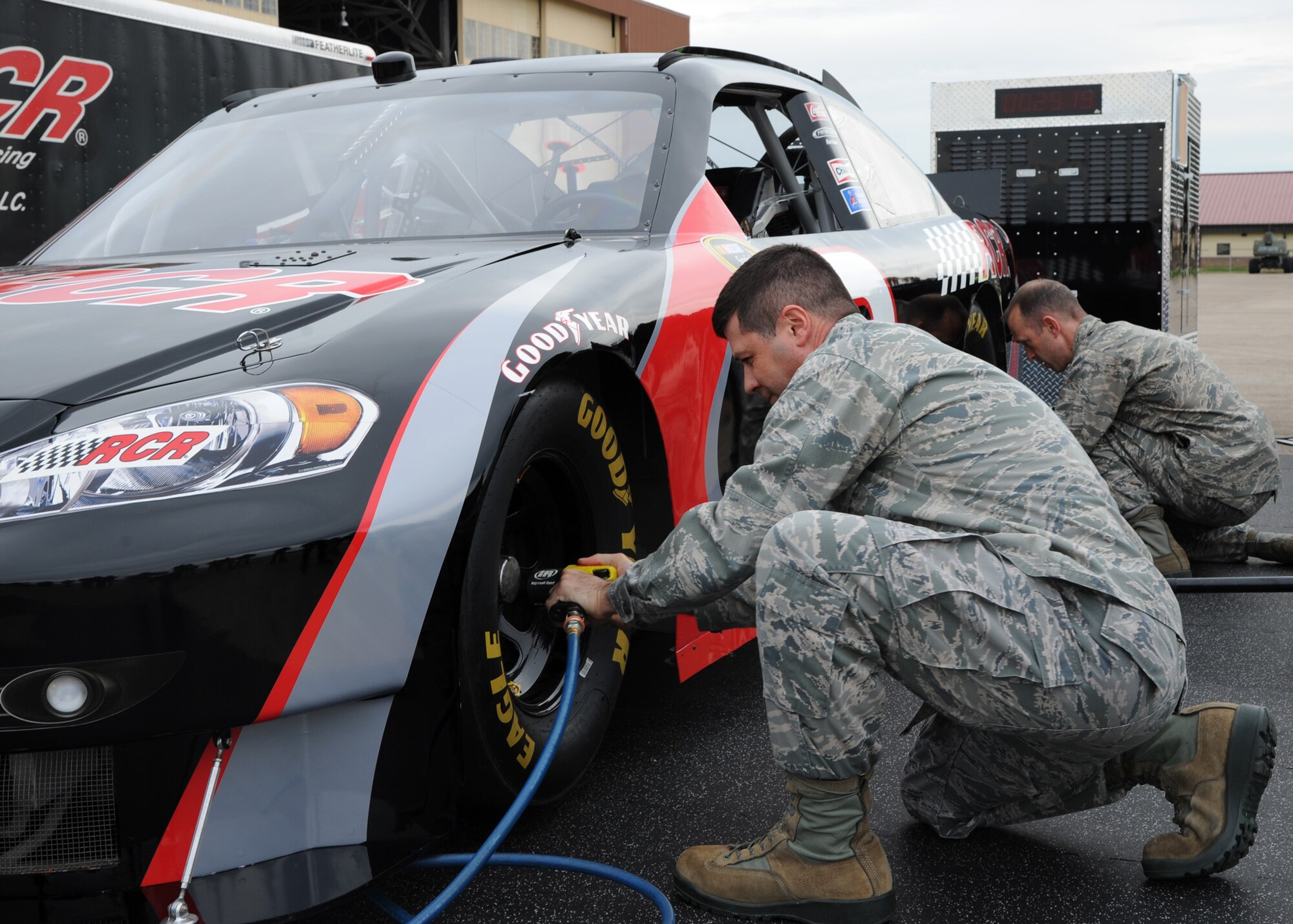Col. Andrew Gebara, 2nd Bomb Wing commander, simulates removing a tire during a pit crew challenge at Hoban Hall on Barksdale Air Force Base, La., Dec. 28, 2013. Gebara used a pneumatic drill to unscrew and tighten five lug nuts on two tires. (U.S. Air Force photo/Senior Airman Joseph A. Pagán Jr.)

