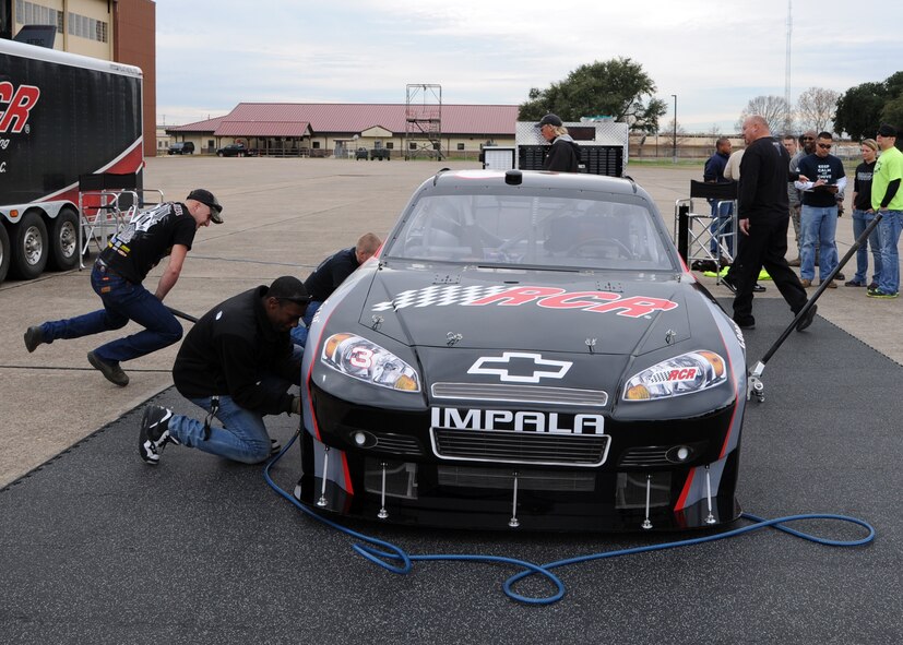 Airmen and family members compete in the pit crew challenge at Hoban Hall on Barksdale Air Force Base, La., Dec. 28, 2013. The event consisted of three-man teams who had to simulate what actual pit crew members would experience during a race. (U.S. Air Force photo/Senior Airman Joseph A. Pagán Jr.)