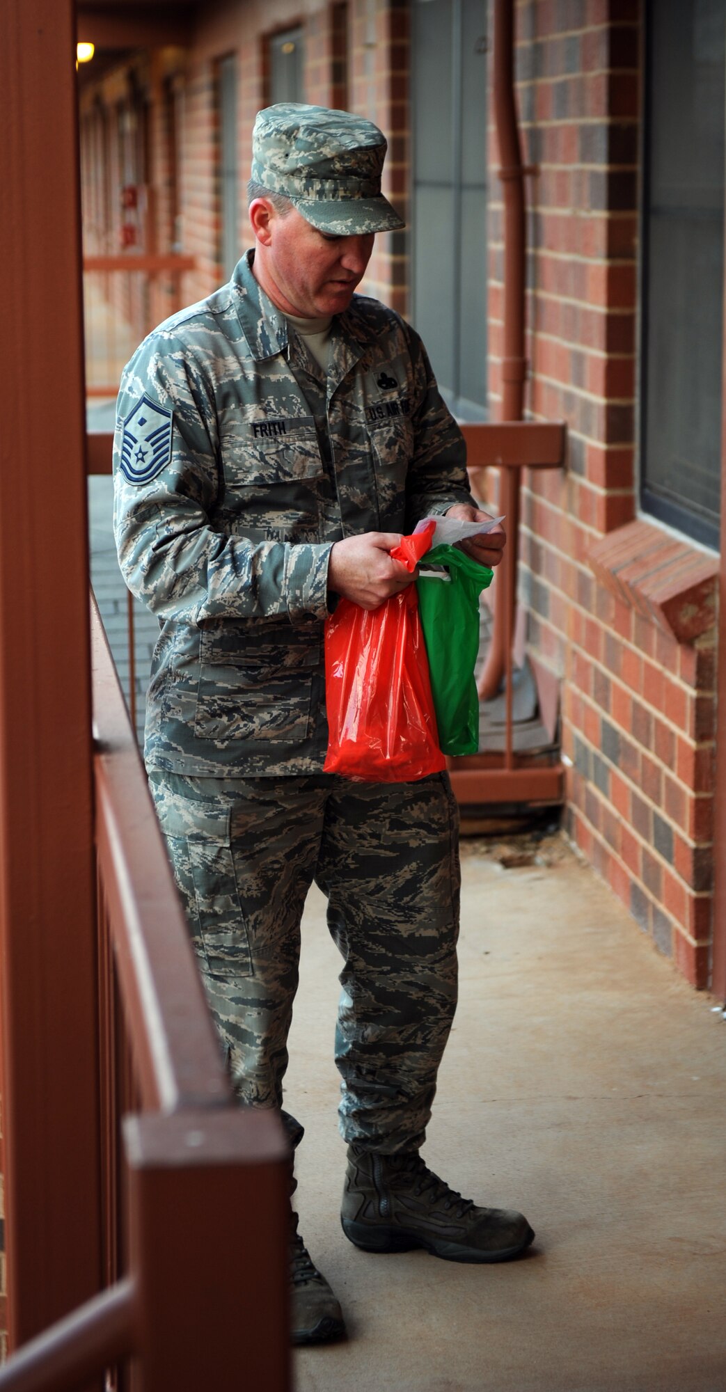 U.S. Air Force Master Sgt. John Frith, 7th Bomb Wing staff agencies first sergeant, delivers cookies to dorm residents during the annual Cookie Drop Dec. 13, 2013, at Dyess Air Force Base, Texas. In the U.S. Air Force, First Sergeant is not a rank, but a special duty held by a senior enlisted member of a military unit who reports directly to the unit commander. This billet is held by individuals of pay grades Master Sgt. through Chief Master Sgt. (U.S. Air Force photo by Airman 1st Class Alexander Guerrero/Released)
