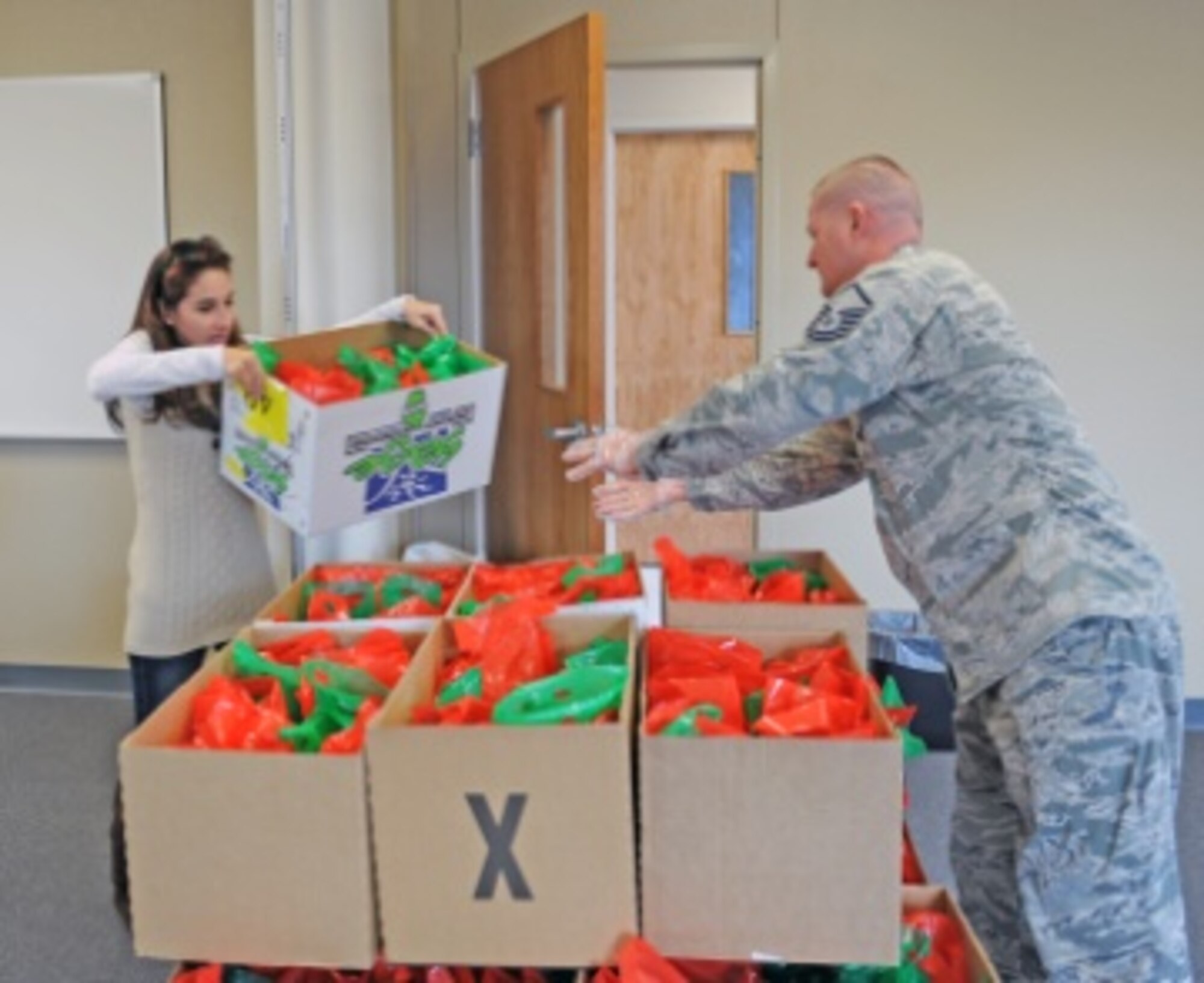 U.S. Air Force Master Sgt. Joshua Anderson, 7th Bomb Wing Inspection Superintendent, helps organize boxes of cookies for the annual Cookie Drop Dec. 13, 2013, at Dyess Air Force Base, Texas. The first sergeants volunteered to delivered cookies to dorm residents for the holidays in order to help boost morale. (U.S. Air Force photo by Airman 1st Class Kedesha Pennant/Released)