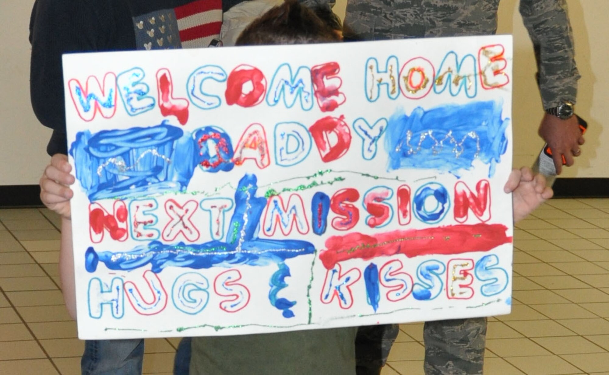 Upon returning home from a two-month deployment to Afghanistan, one Airman from the 301st Fighter Wing received another tasking order, "Next mission: hugs & kisses." (U.S. Air Force photo/Laura Dermarderosiansmith)