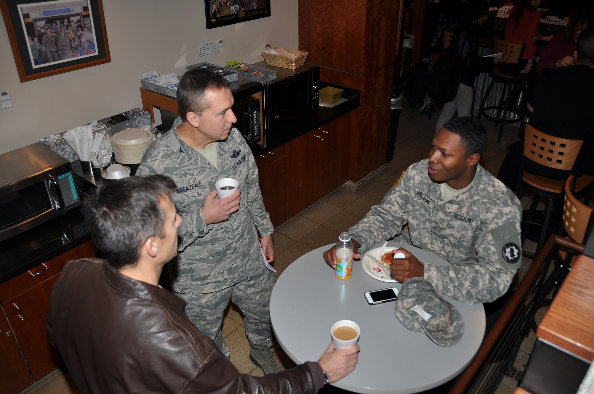 Col. Kevin Zeller, 301st Operations Group commander, left, and Col. John M. Breazeale, 301st Fighter Wing commander, center,  take time on Christmas eve to talk with traveling servicemembers at the USO at Dallas-Fort Worth International Airport while waiting for the arrival of several flights throughout the day bringing many of the wing's Airmen home from a two-month deployment to Afghanistan.  (U.S. Air Force photo/Laura Dermarderosiansmith) 