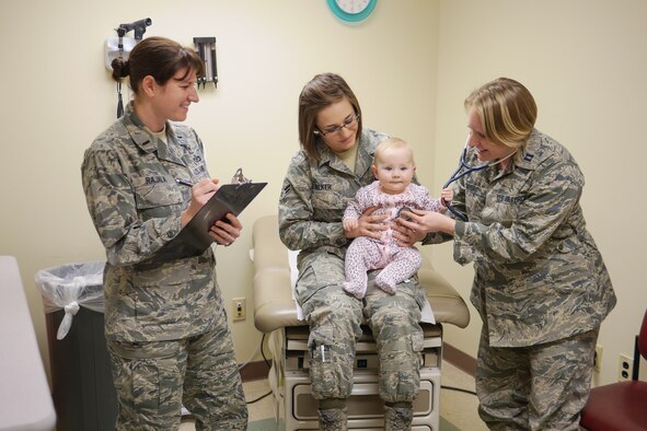 Capt. (Dr.) Carolyn Moore, 1st Lt. Marie Rajala, and Airman 1st Class Holly Walker from the 377th Medical Group work together to care for a young patient as a Patient Centered Medical Home team, which is comprised of a doctor, nurse, and technician. (Courtesy photo)