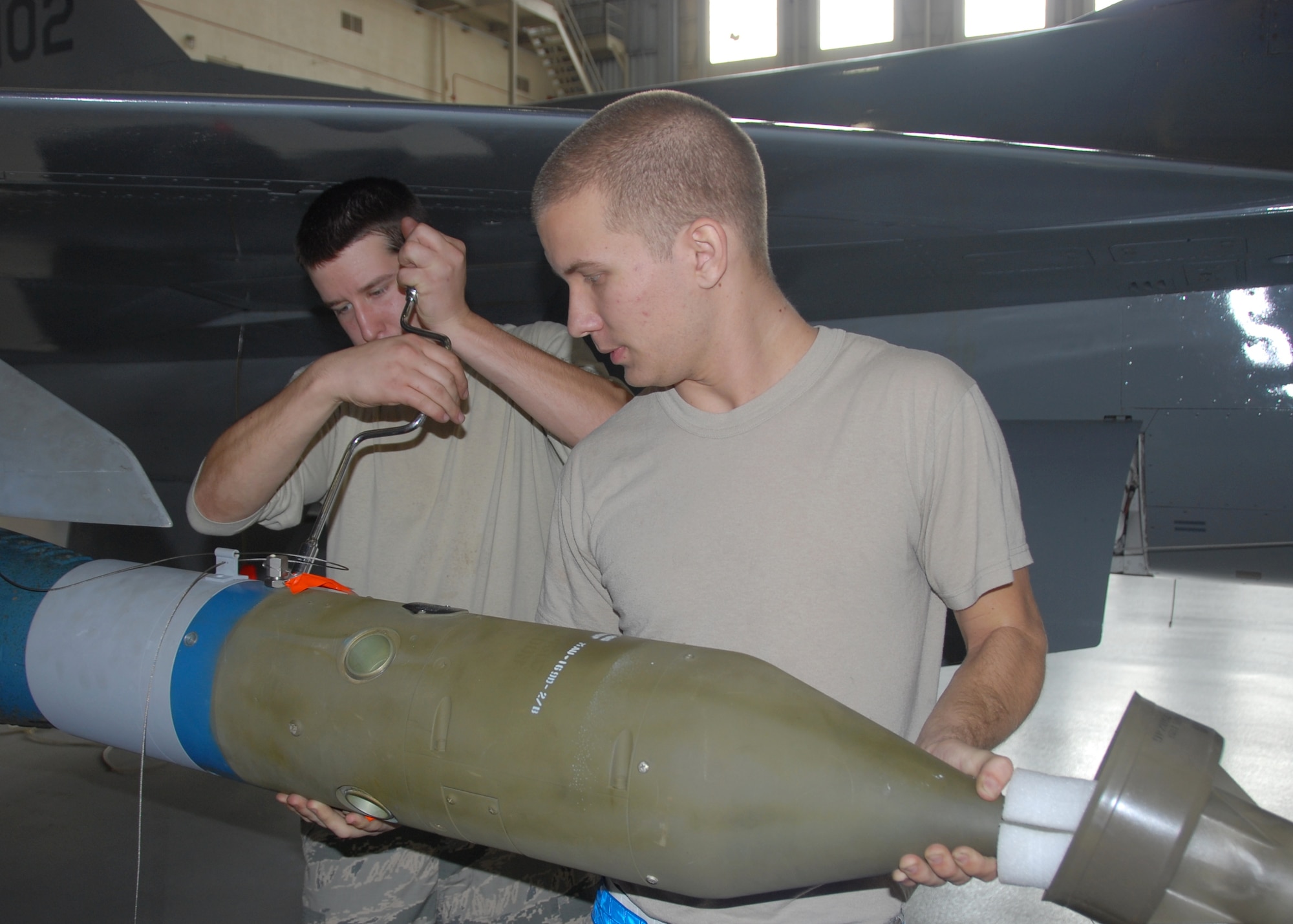 Senior Airman Derron Ackermann and Staff Sgt. Kevin Vinson, of the 96th Aircraft Maintenance Squadron Blue, insert and screw down the forward guidance unit on their F-16 Fighter Falcon, during the 96th Maintenance Group’s quarterly weapons loadcrew competition Dec. 20 at Eglin Air Force Base, Fla.  Vinson, Ackermann and Airman First Class Brandon Browning represented the Blue AMU.  The Blue team defeated the Red Team in the competition. (U.S. Air Force photo/Kevin Gaddie)