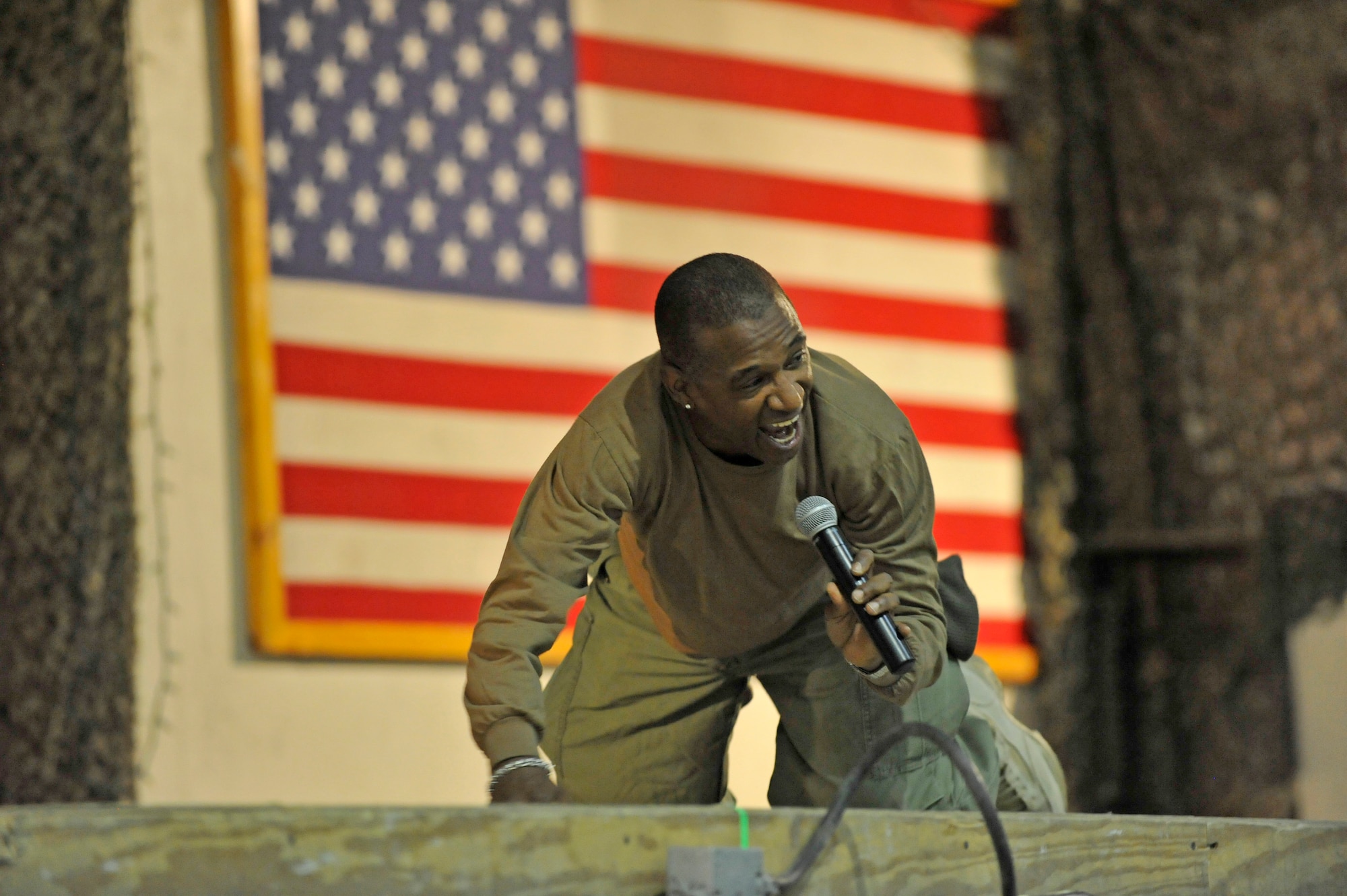 Comedian Tommy Davidson gets low and shows what he would do if he received indirect fire during his comedy tour at Bagram Airfield, Afghanistan, Dec. 31, 2013. Davidson performed a comedy routine for deployed Service members on New Year's Eve.(U.S. Air Force photo by Senior Master Sgt. Gary J. Rihn/Released)
