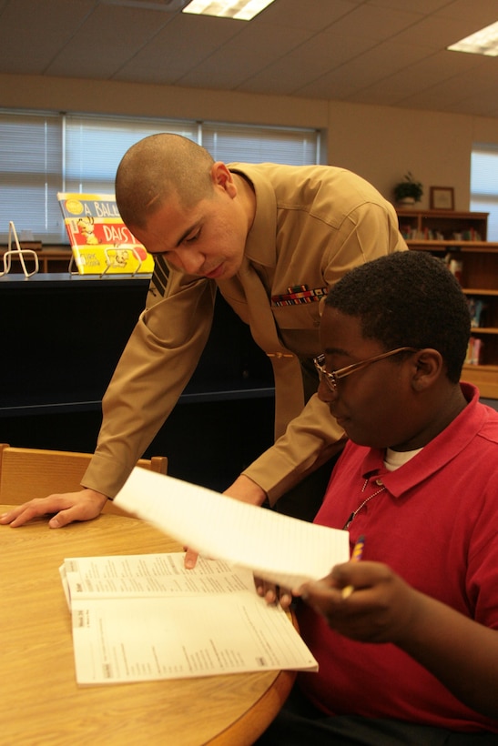 Sgt. Martin Sanchez Jr., an instructor with the Center for Naval Aviation Technical Training, tutors children at the Havelock Elementary School on Jan. 22. Sanchez and his wife, Ruby, were selected as the Havelock Military Affairs Committee's family of the quarter.