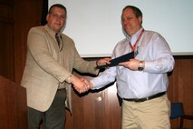 Jim Westerholm (left), Marine Air-Ground Task Force Command, Control and Communications deputy program manager, presents Dave Garvin with the President's Call to Service Award during the MAGTF C3 Town Hall Jan. 16, 2013.