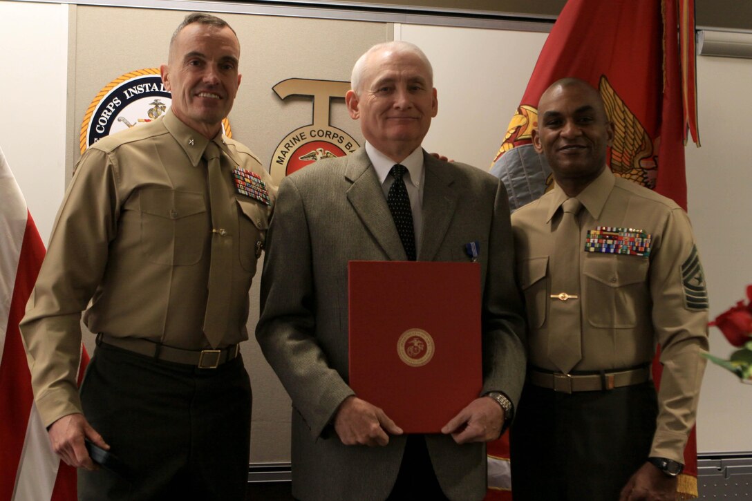 Brig. Gen. Vincent Coglianese, left, poses with Thomas Farrell, center, and Sgt. Maj. Derrick Christovale Sr., right, after presenting Farrell with the Commendation for Superior Civilian Service award here Feb. 1. Farrell is the assistant chief of staff for G-1 here. Coglianese is the base commanding general and regional authority for five military installations in the Southwestern United States. Christovale is senior enlisted advisor.