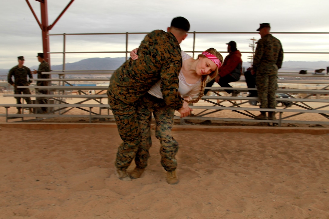 Rochelle Kimmel hip tosses her husband Cpl. Gavin Kimmel, squad leader, Weapons Co, 3rd Battlion, 7th Marine Regiment, Jan. 24, 2013, during the unit’s Marine Corps Martial Arts Program portion Jane Wayne Day.
