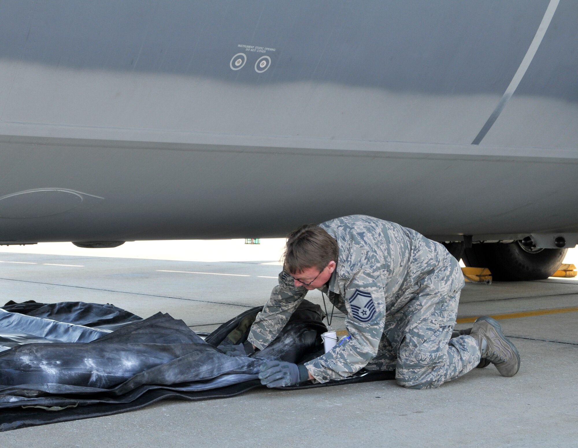 Senior Master Sgt. Farris Riggsbee, 920th RQW Crash, Damage, Disabled Aircraft Recovery team member positions an air bag under the belly of a C-130. Riggsbee along with other Patrick Air Force Base CDDAR members participated in a recent training exercise that simulated the collapse of the nose landing gear on a C-130. (U.S. Air Force photo/Tech. Sgt. Peter Dean)