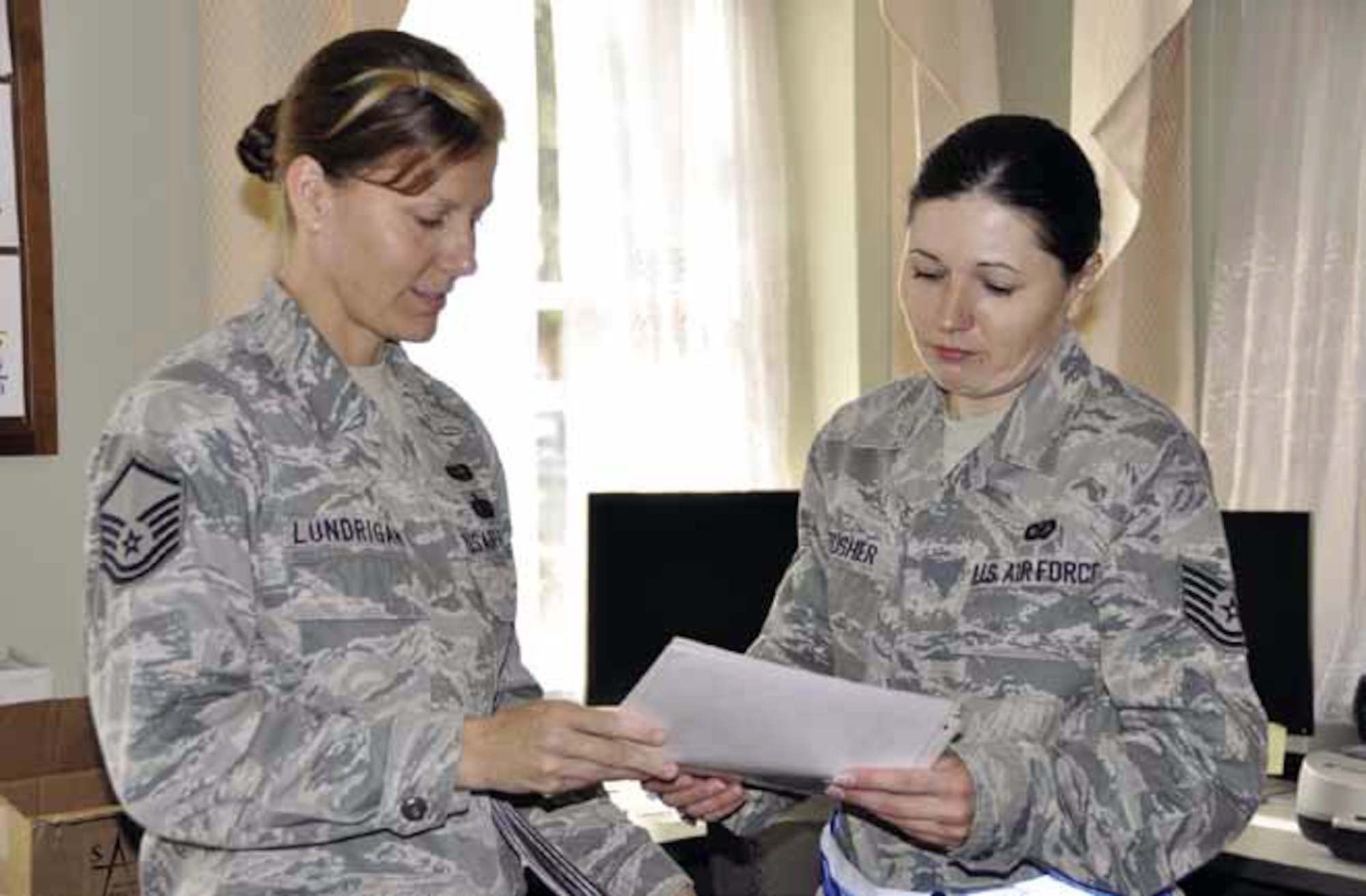 Master Sgt. Kelley Lundrigan (left) 452d Air Mobility Wing unit deployment manager, explains inspection-specific requirements to Tech. Sgt. Megan Crusher, 452d AMW public affairs, during deployment processing, in preparation for the Operational Readiness Inspection, held at Gulfport, Miss., from Jan. 28 to Feb. 2. (U.S. Air Force photo by Master Sgt. Linda Welz)